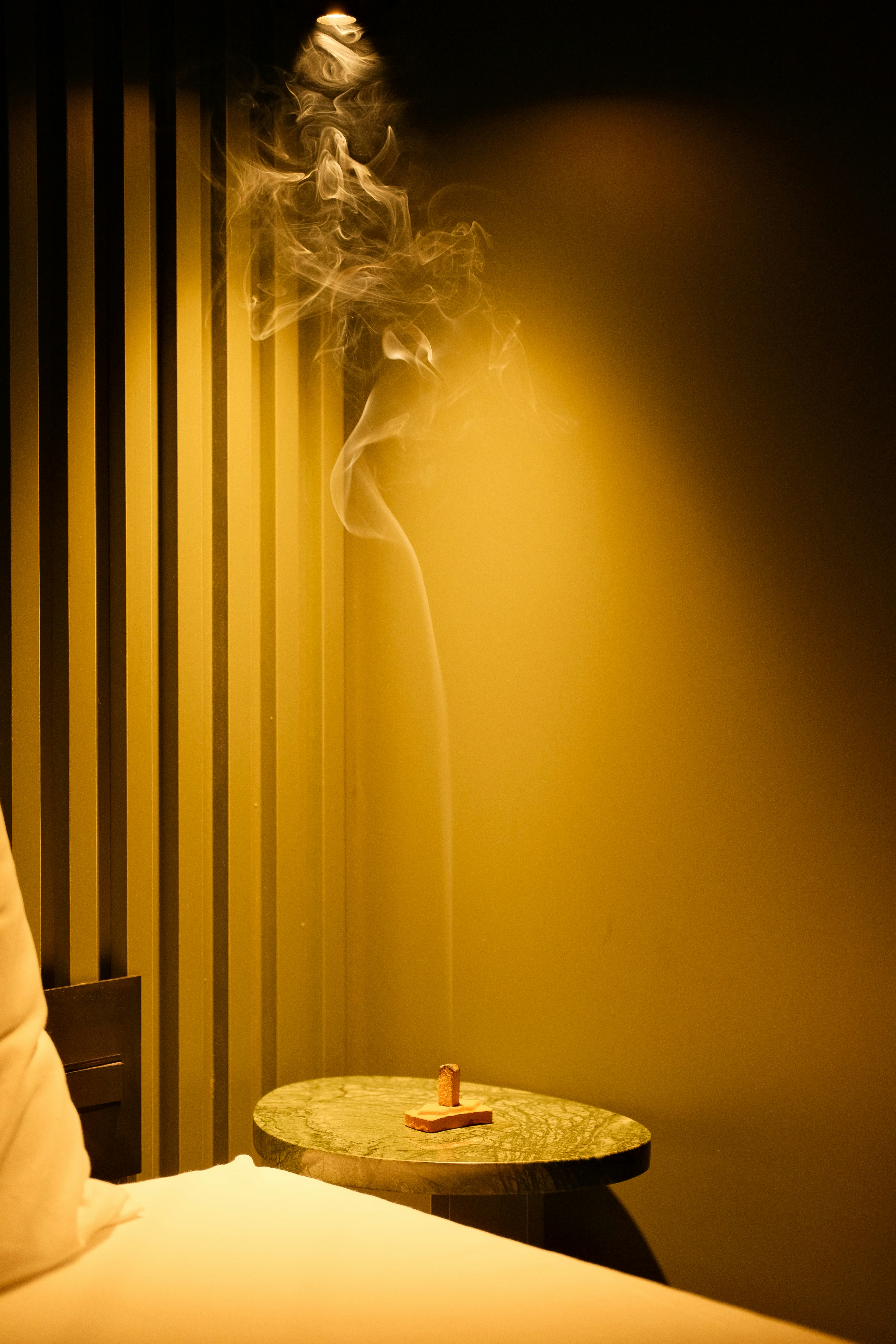 Smoke rising from incense on a marble table.