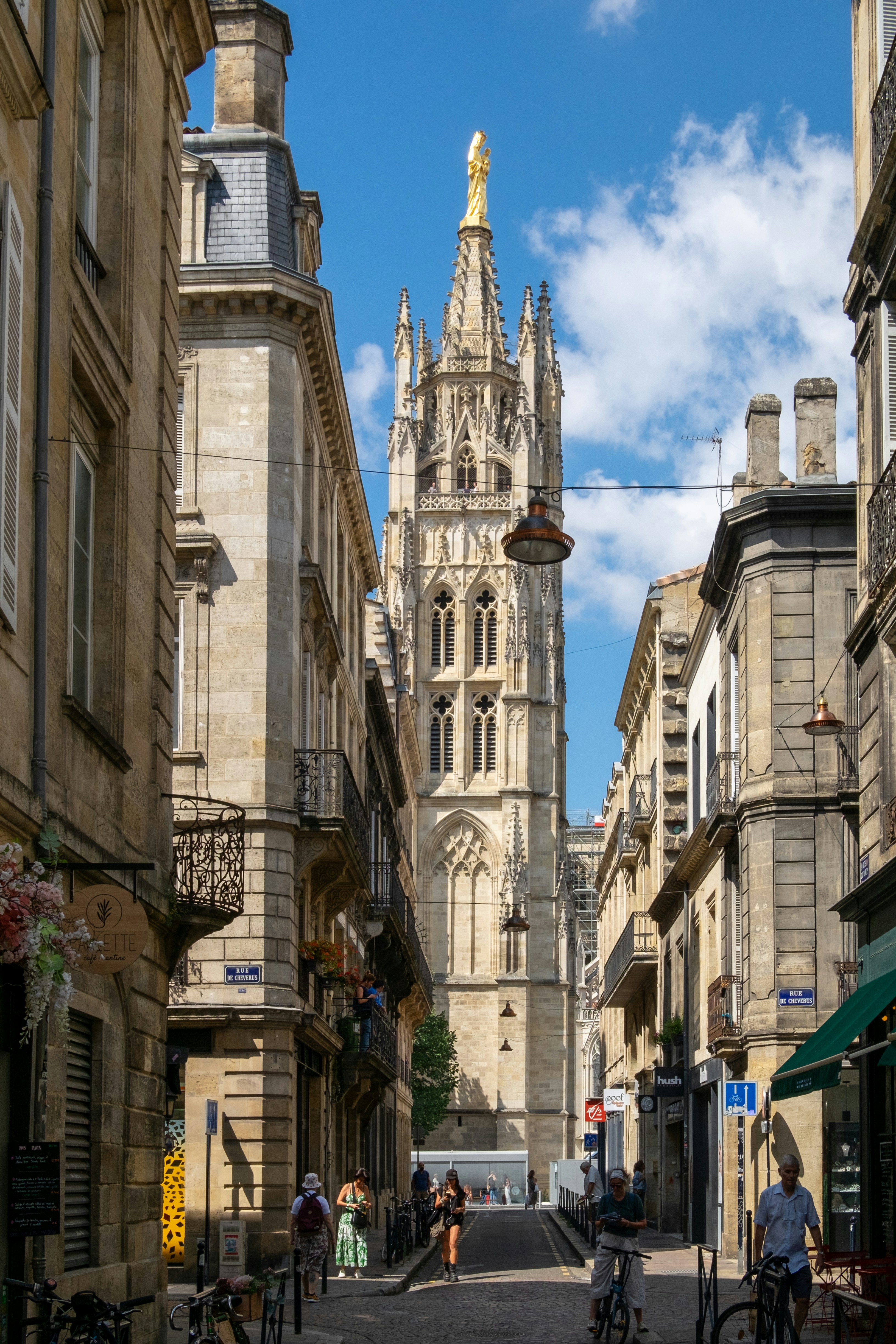 Tall gothic tower rising above narrow european street.