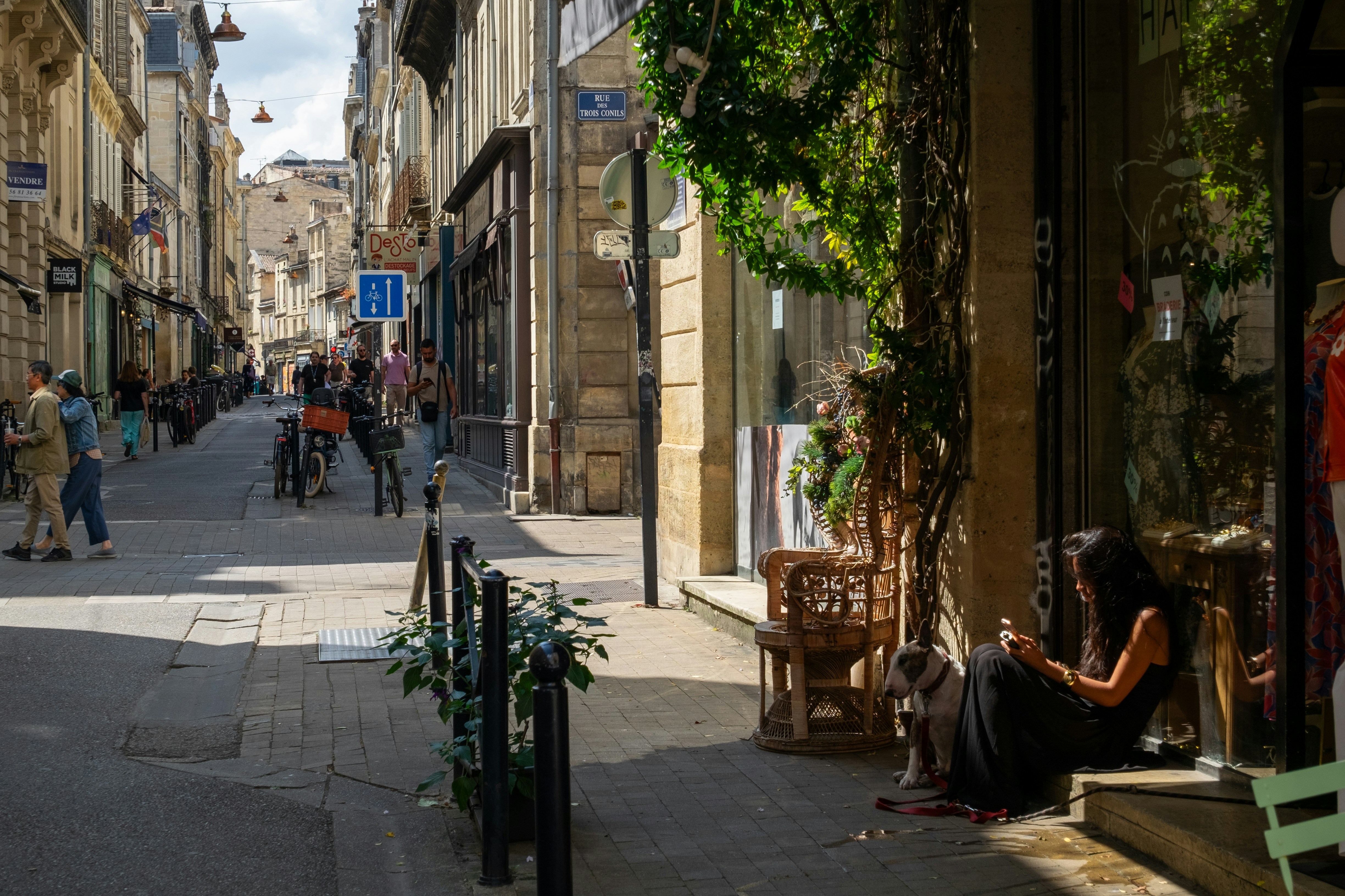 Woman sitting on sidewalk in european street.