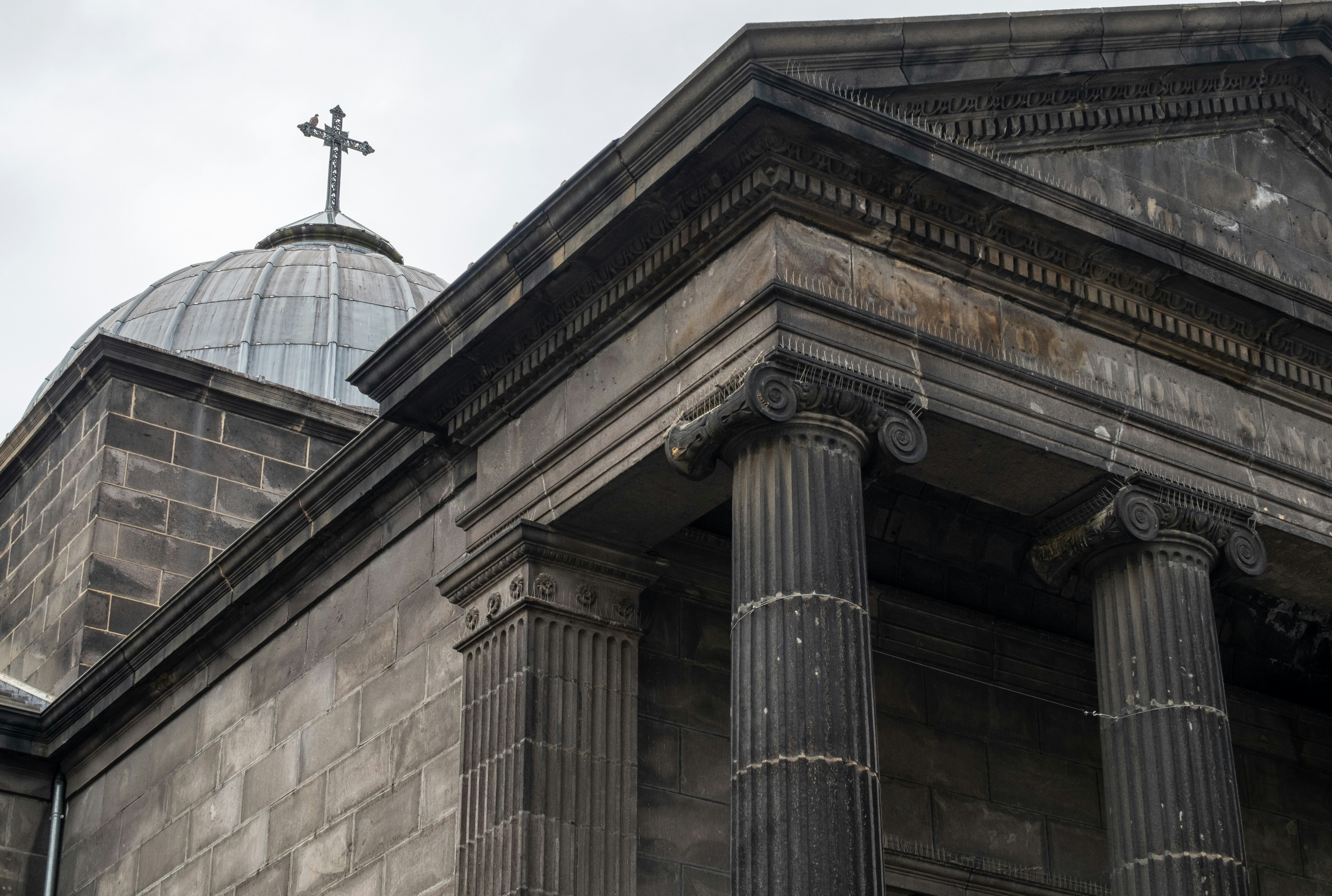 Stone church facade with dome and cross