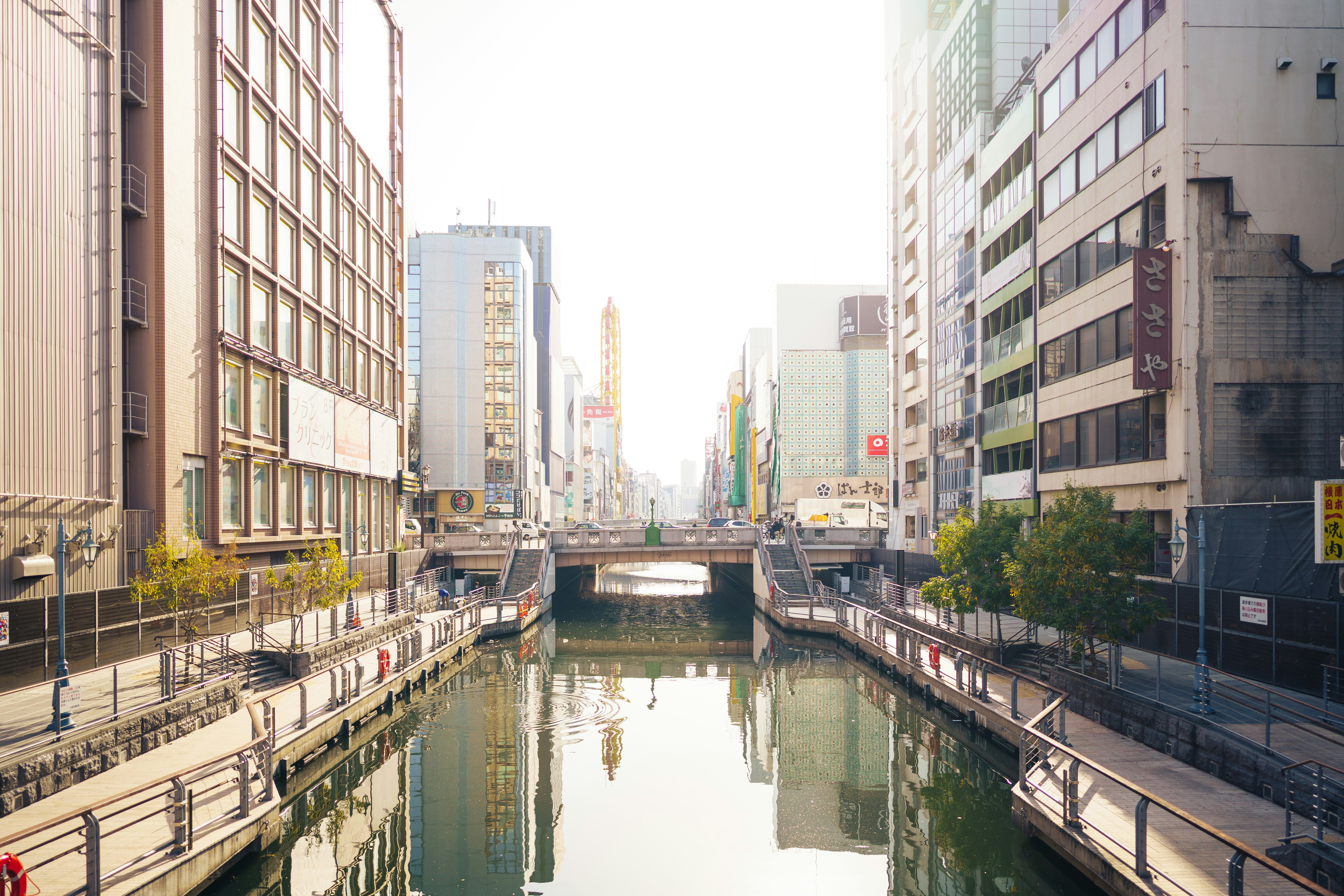 City canal reflecting buildings under bright sunlight