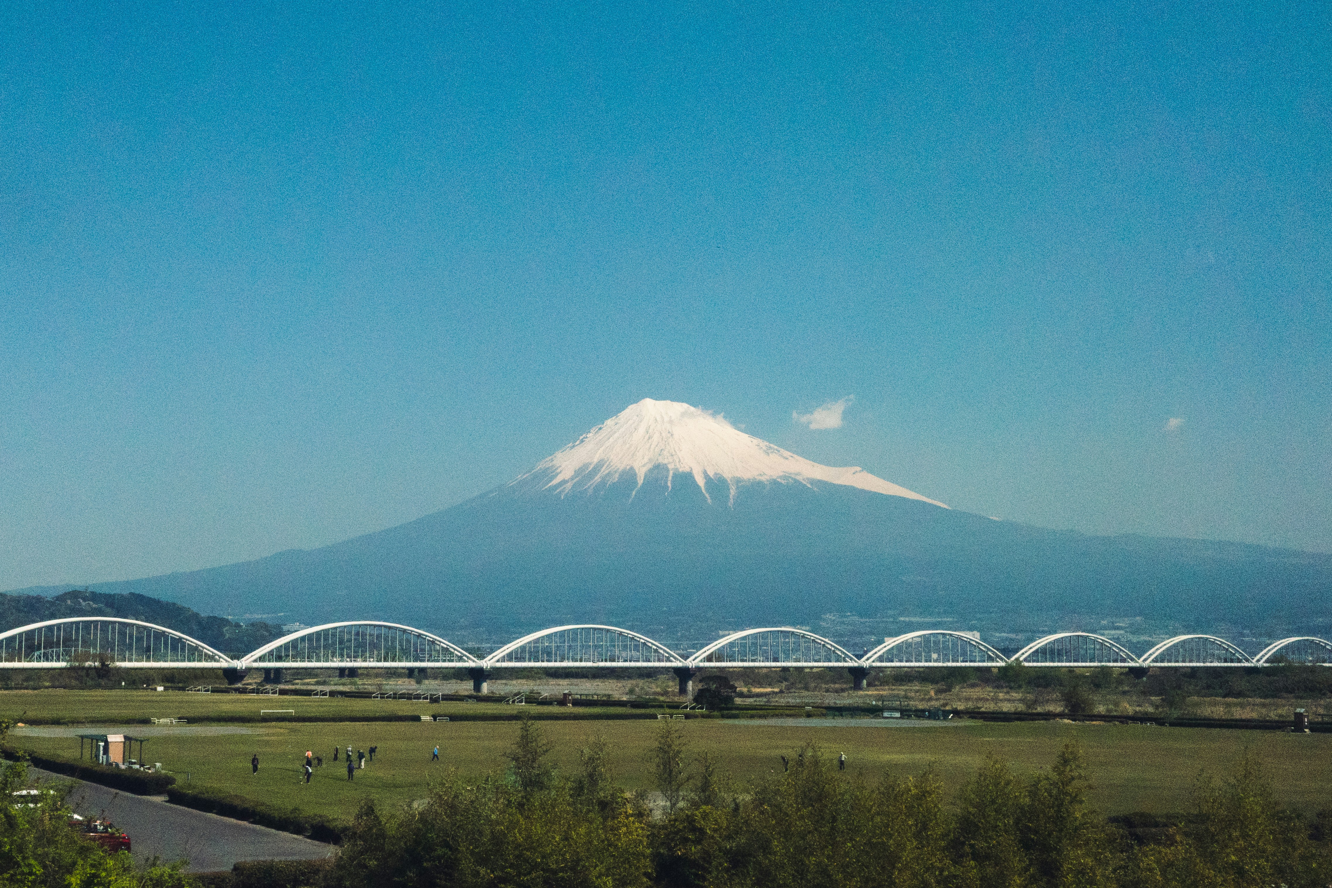Mount fuji with a bridge and green fields