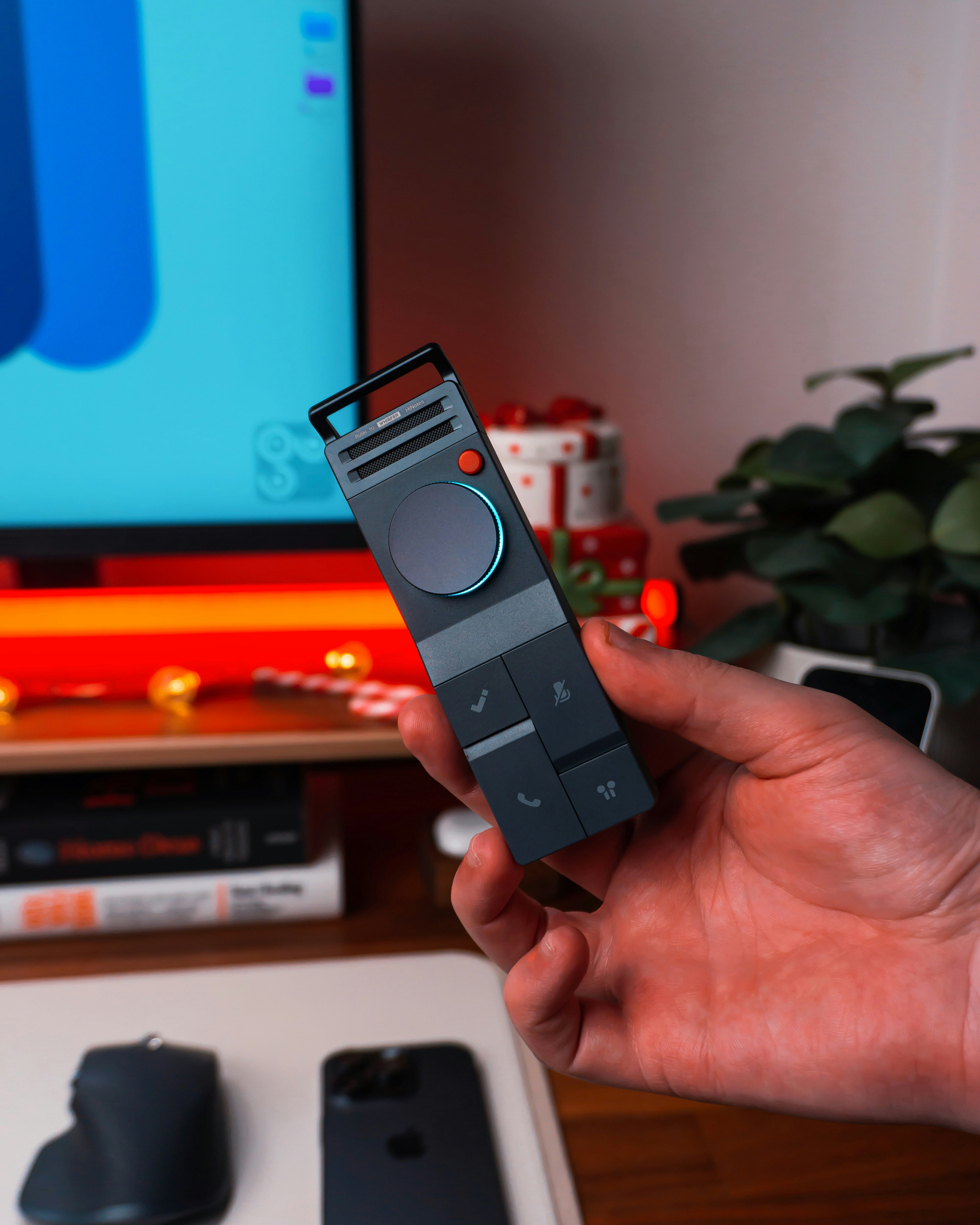 Hand holding a modern remote control device.