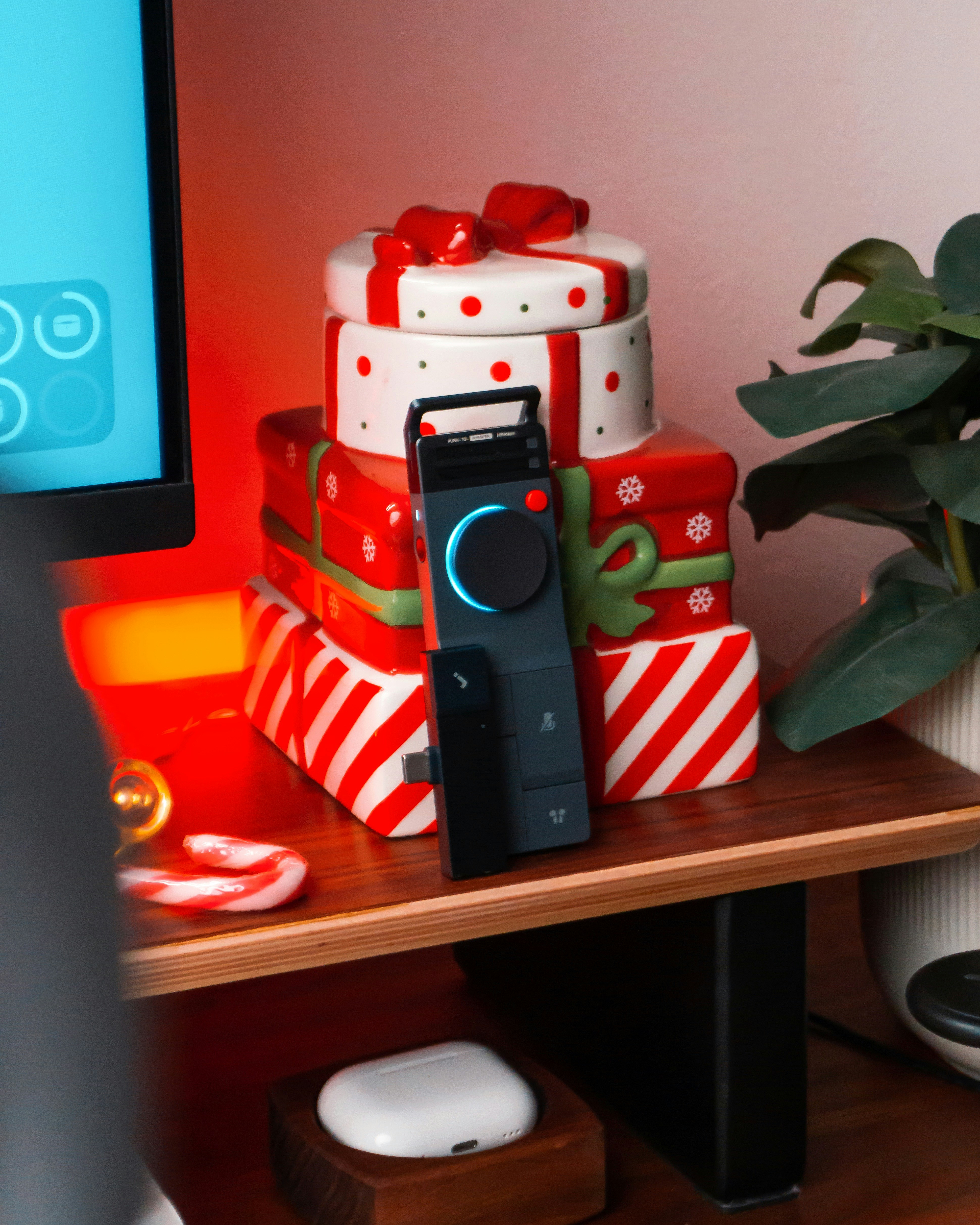 Stack of christmas presents with a remote control.