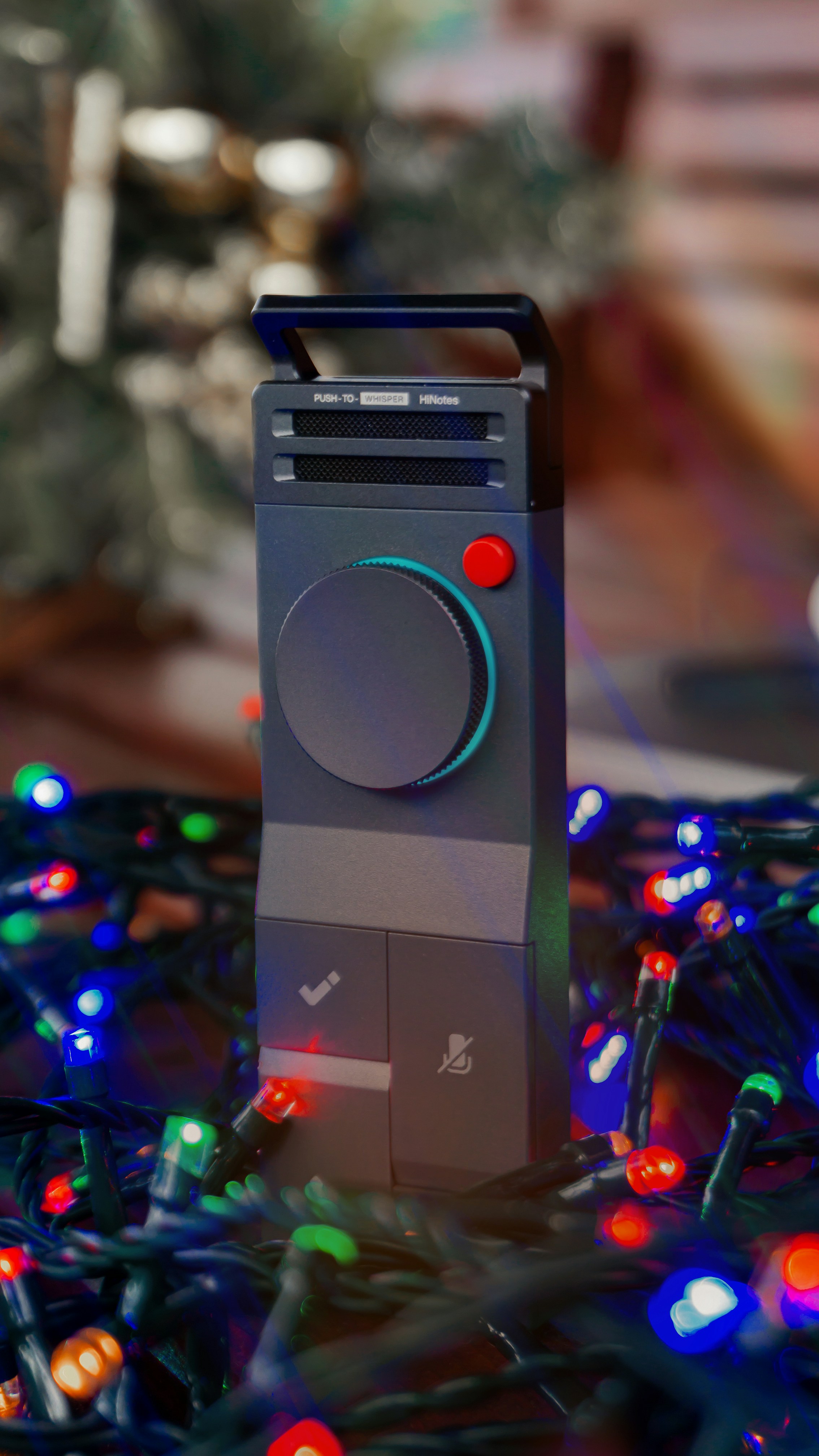 A digital device surrounded by colorful christmas lights.