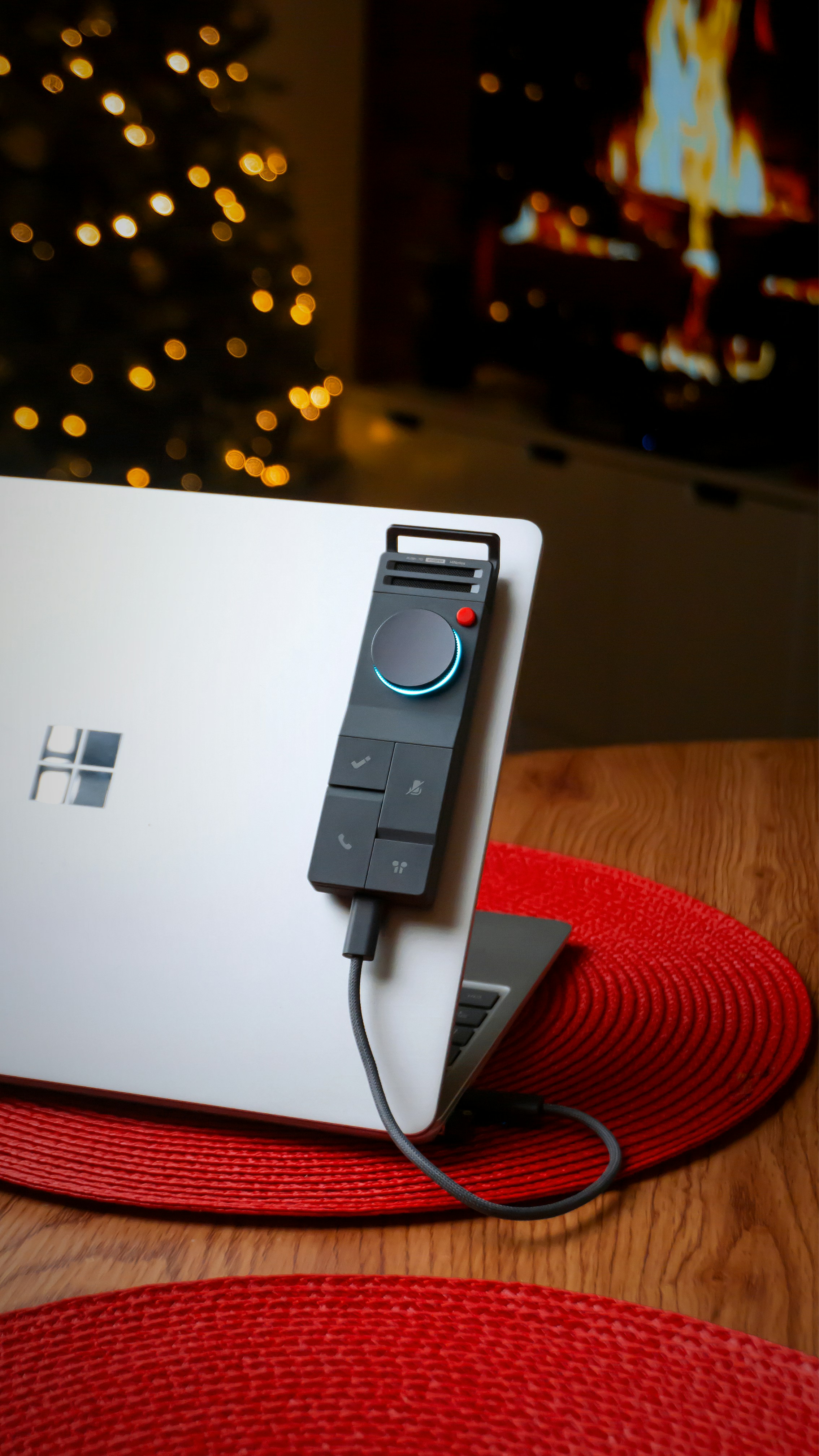 Laptop with a dial controller in a cozy room.