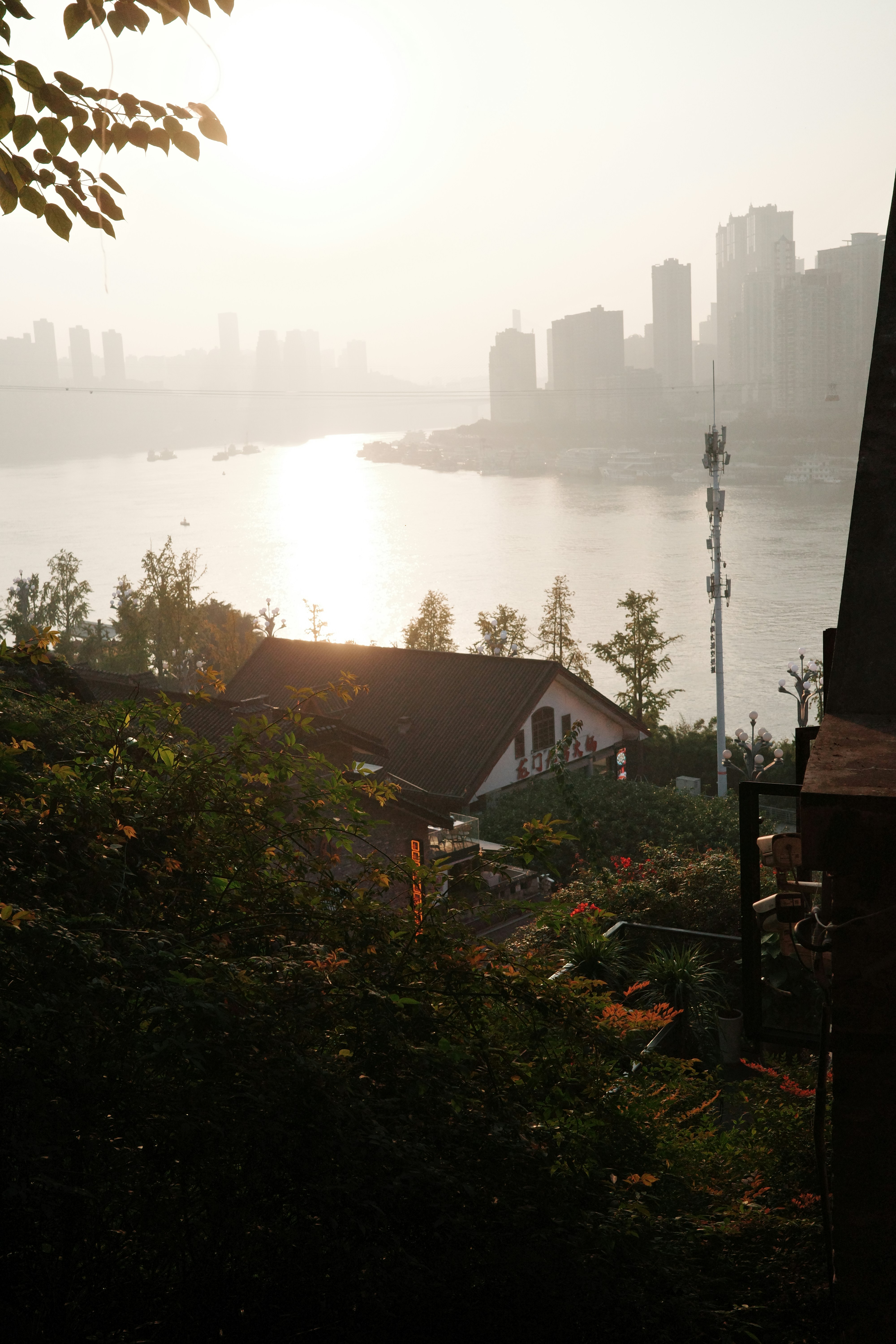 La ligne d’horizon de la ville traverse une large rivière au coucher du soleil.