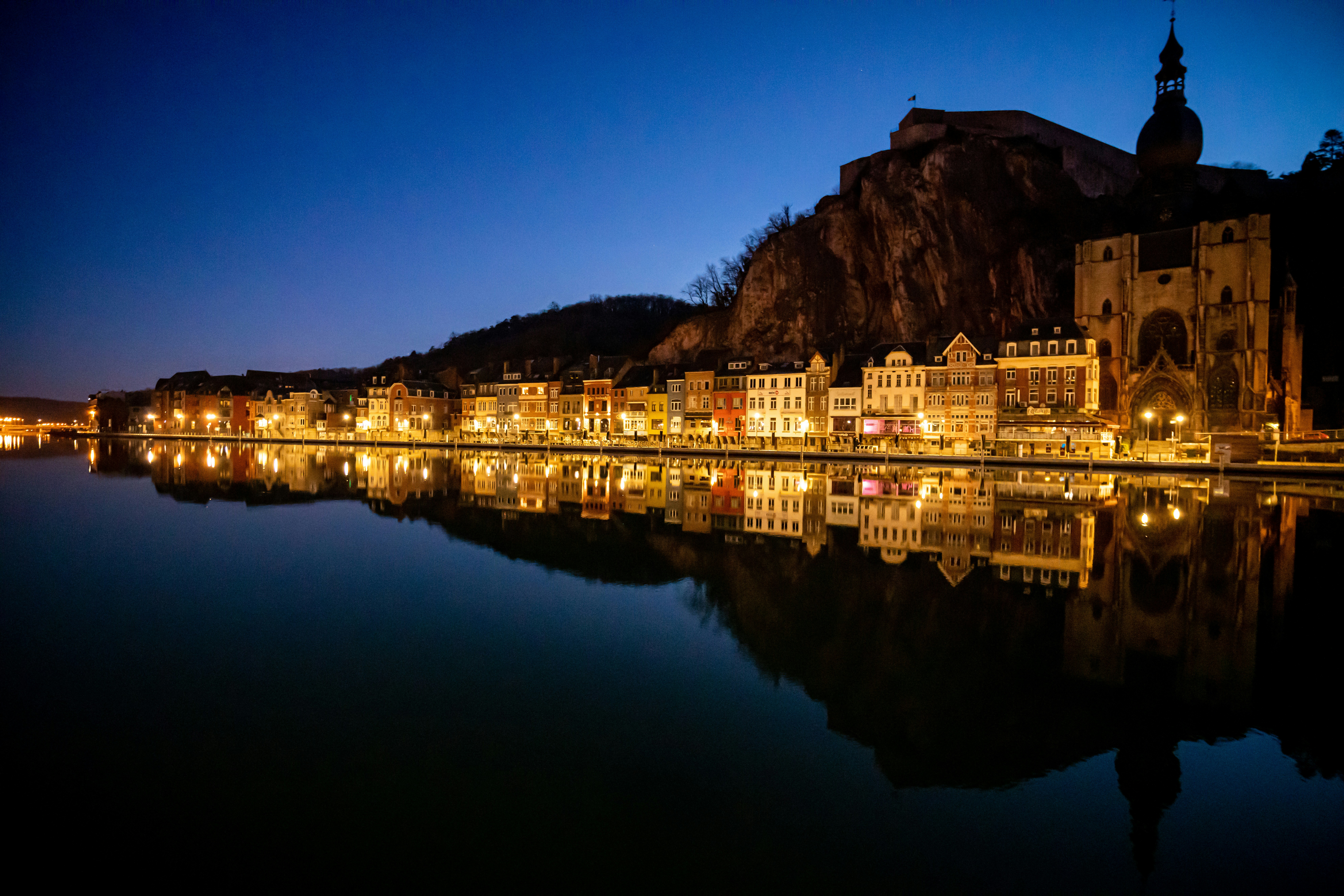 Luzes da cidade refletindo em um rio calmo à noite