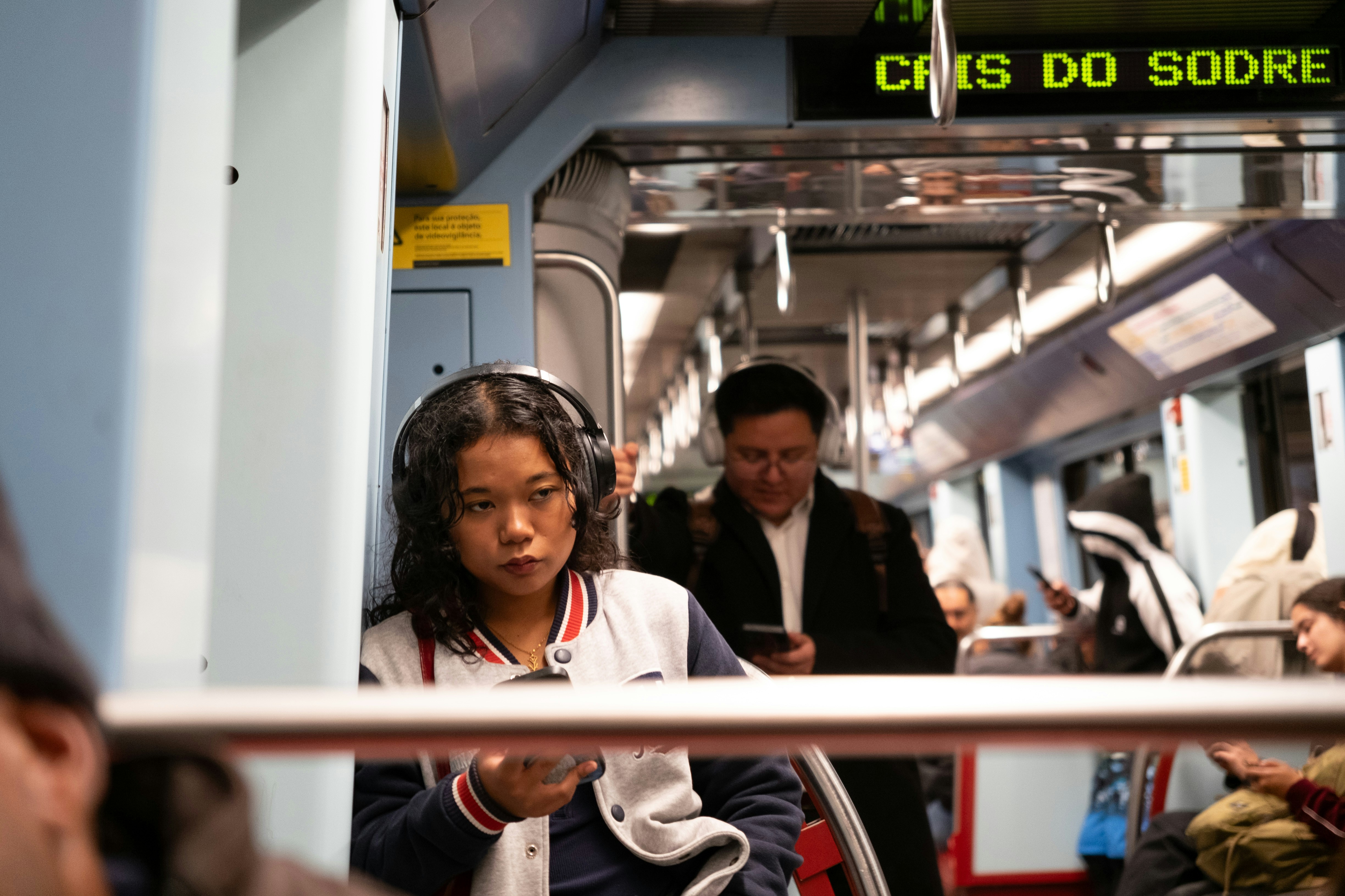 Woman with headphones on a subway train