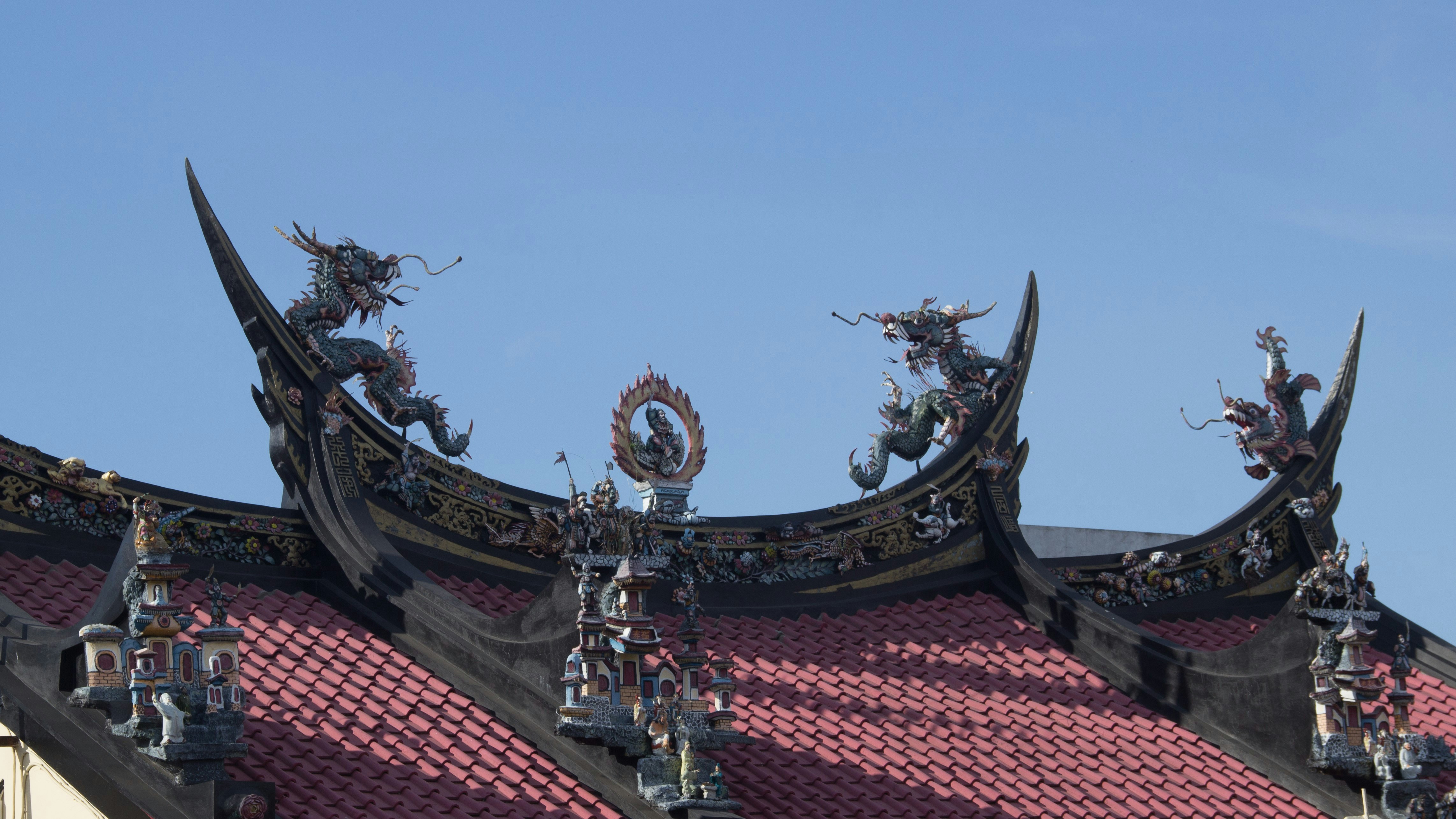 Ornate roof details with dragon figures against blue sky.