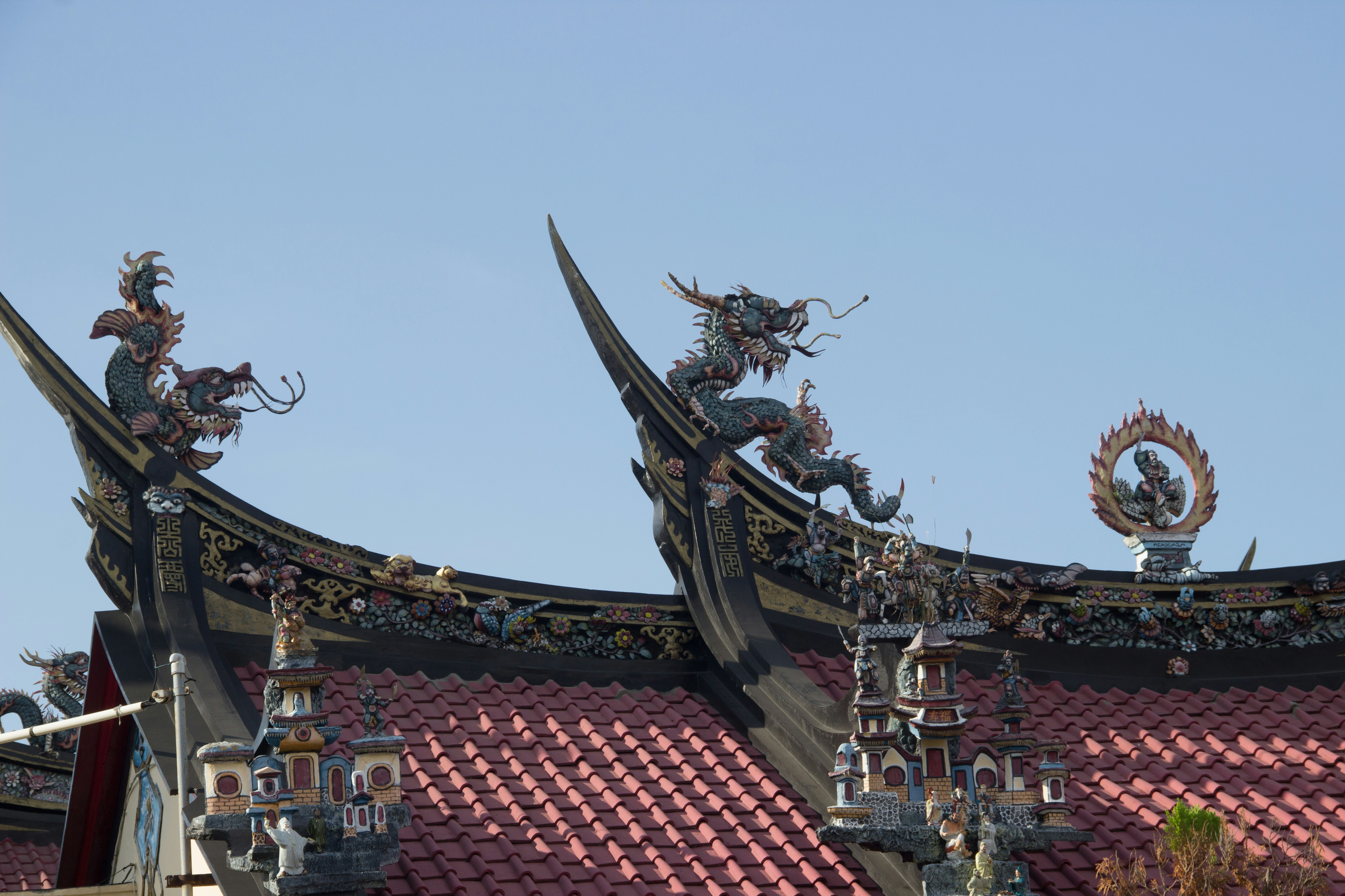 Ornate roof details with dragon sculptures under blue sky