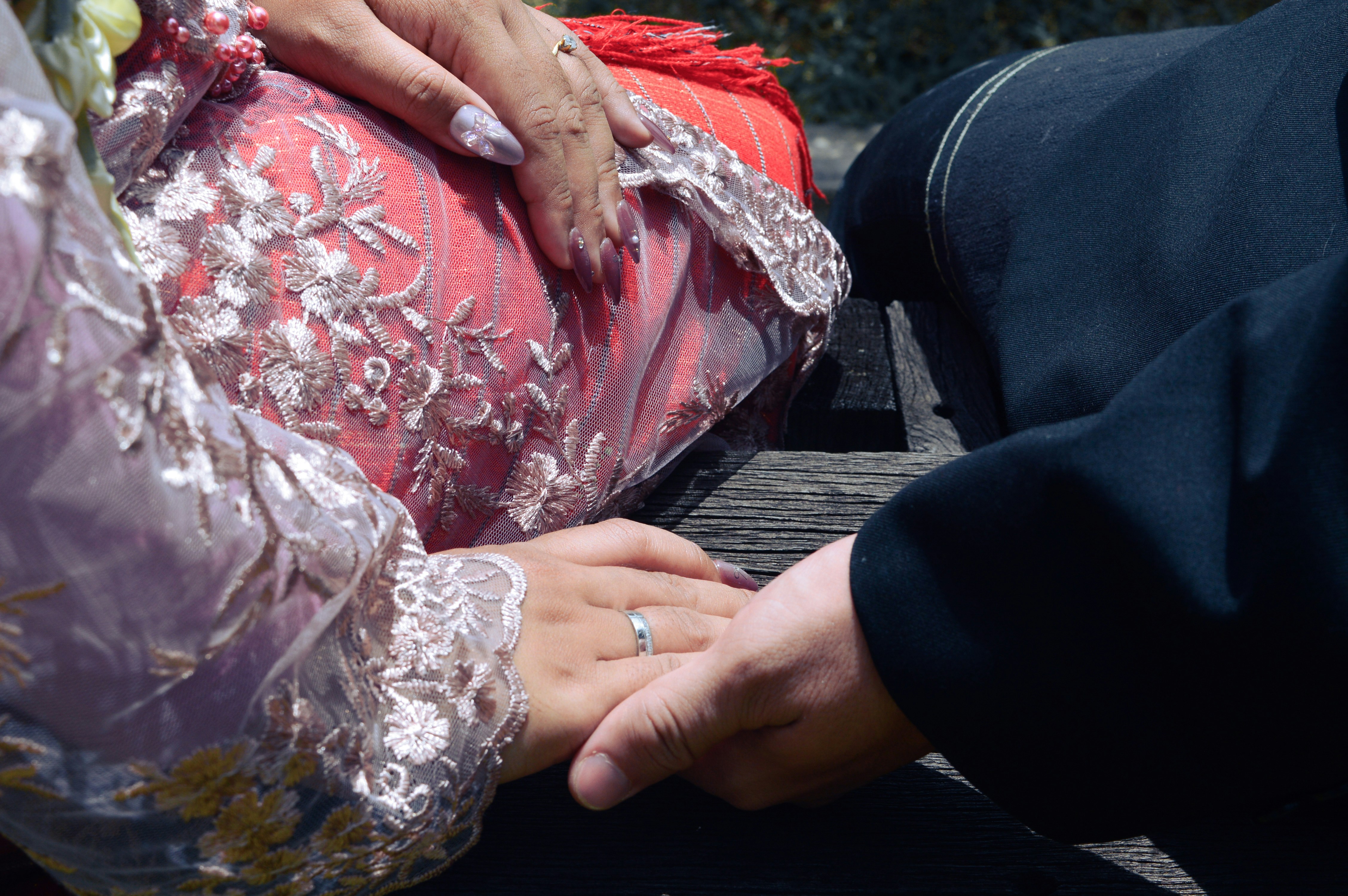 Couple holding hands, wearing traditional attire.