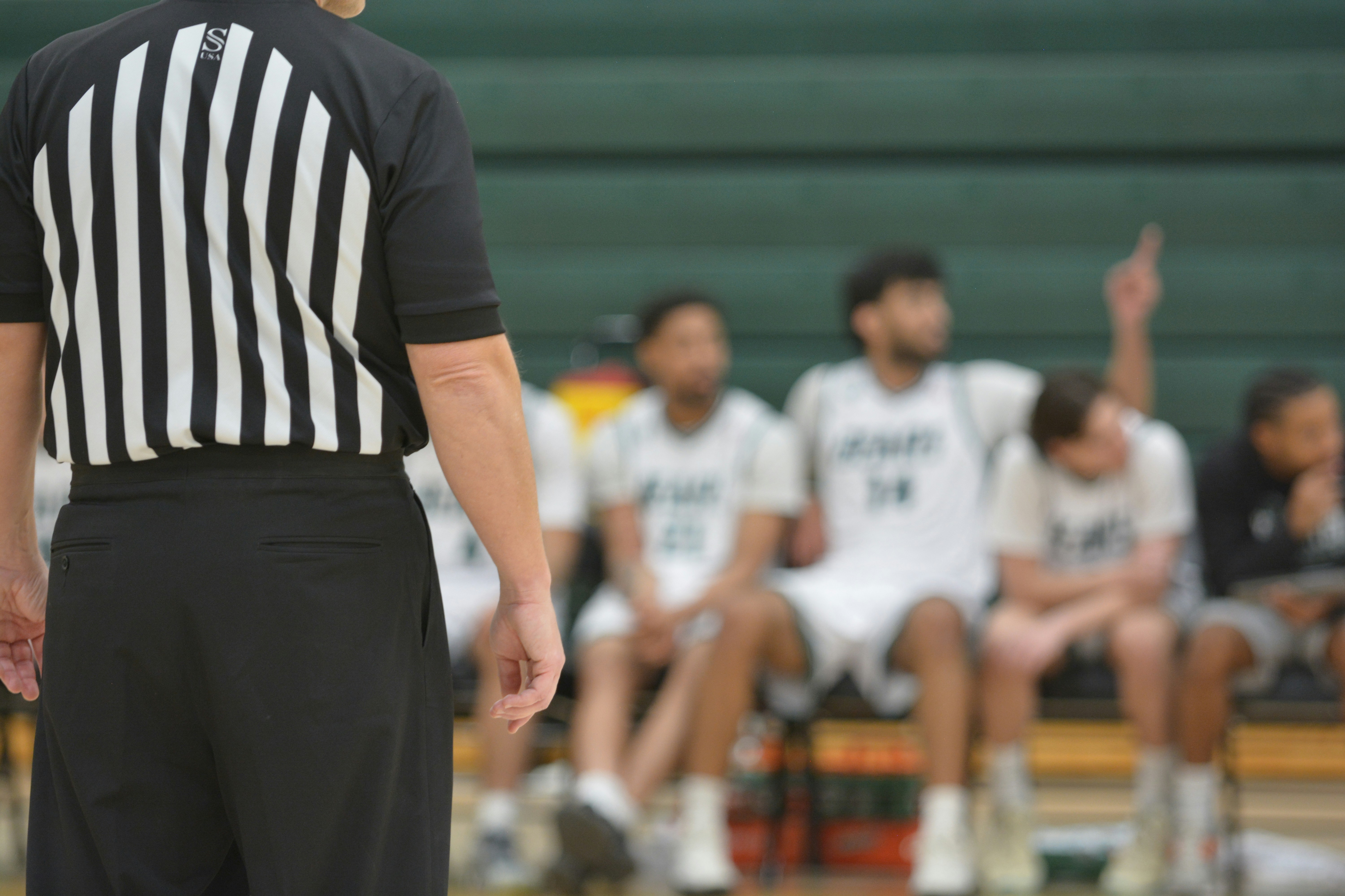 Entrenador ajustando jugadas en una pizarra táctica de baloncesto