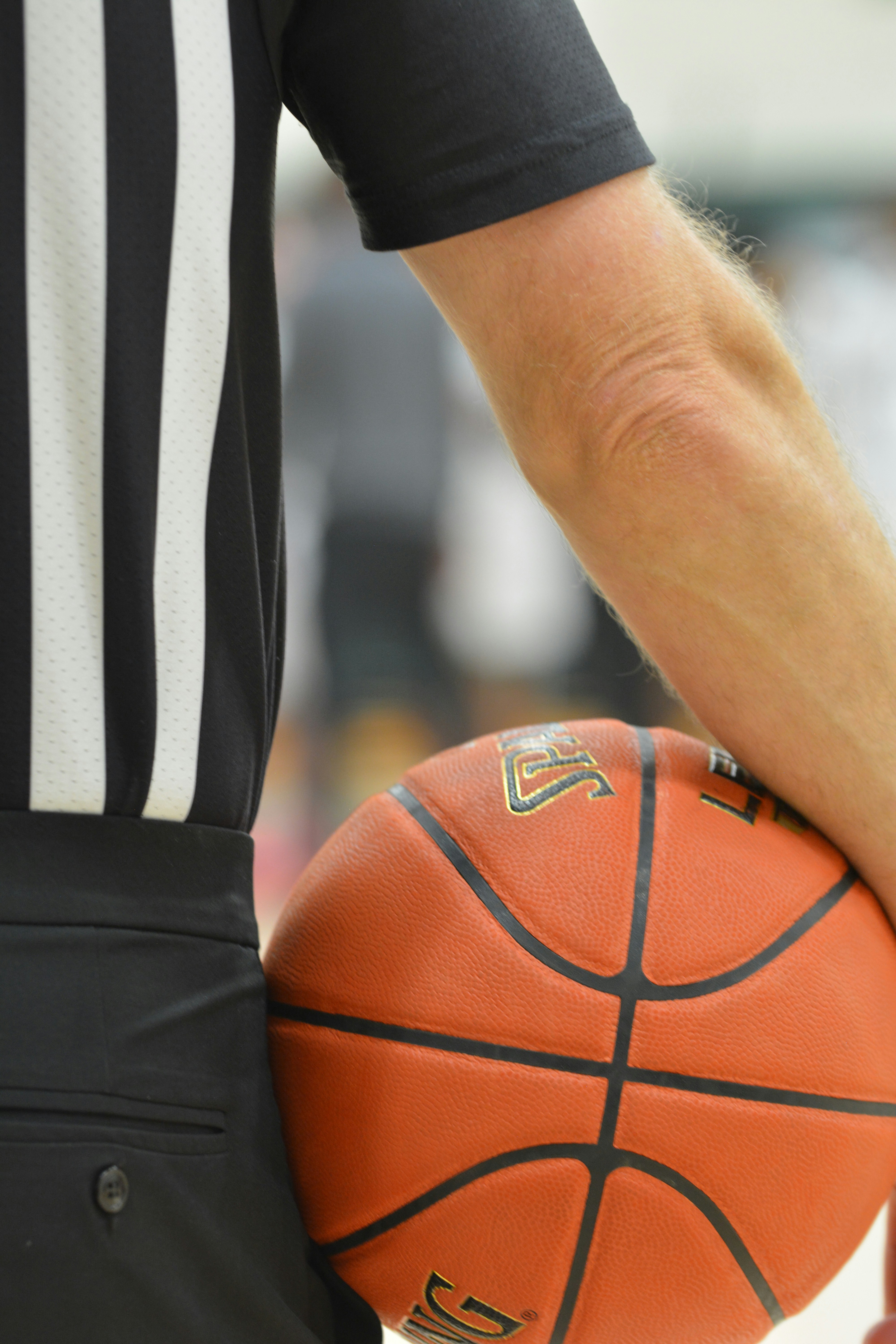 Árbitro de baloncesto sosteniendo un baloncesto naranja
