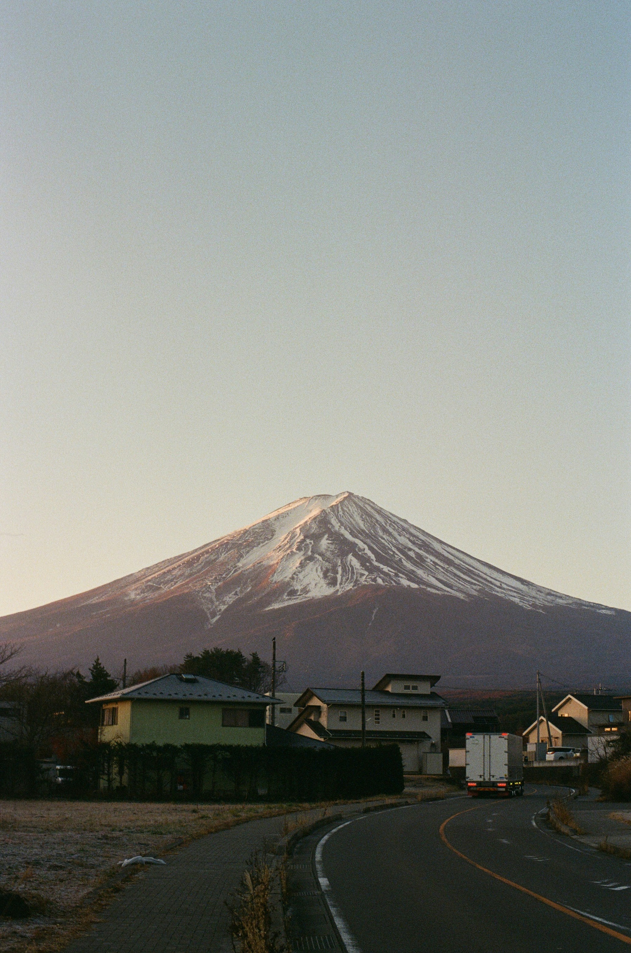 Snow-capped mount fuji with houses and road