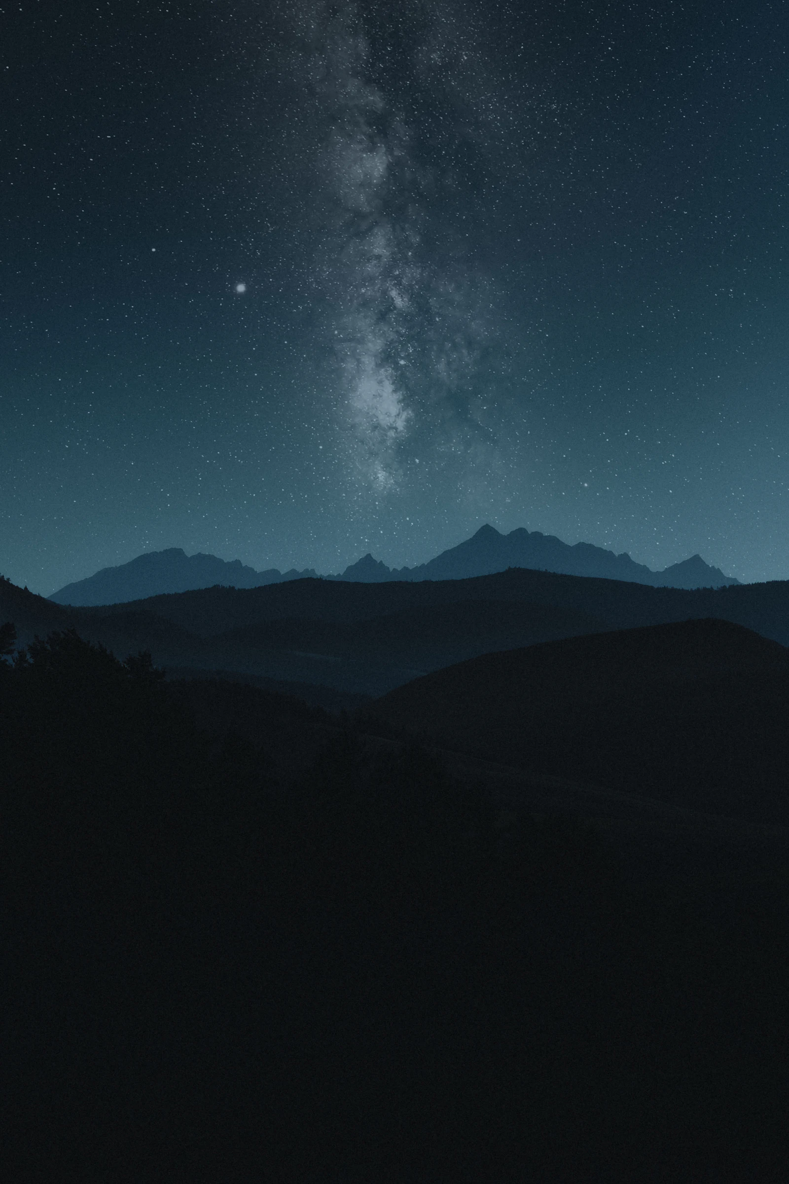 Voie lactée au-dessus de montagnes silhouettées la nuit (image d'illustration)