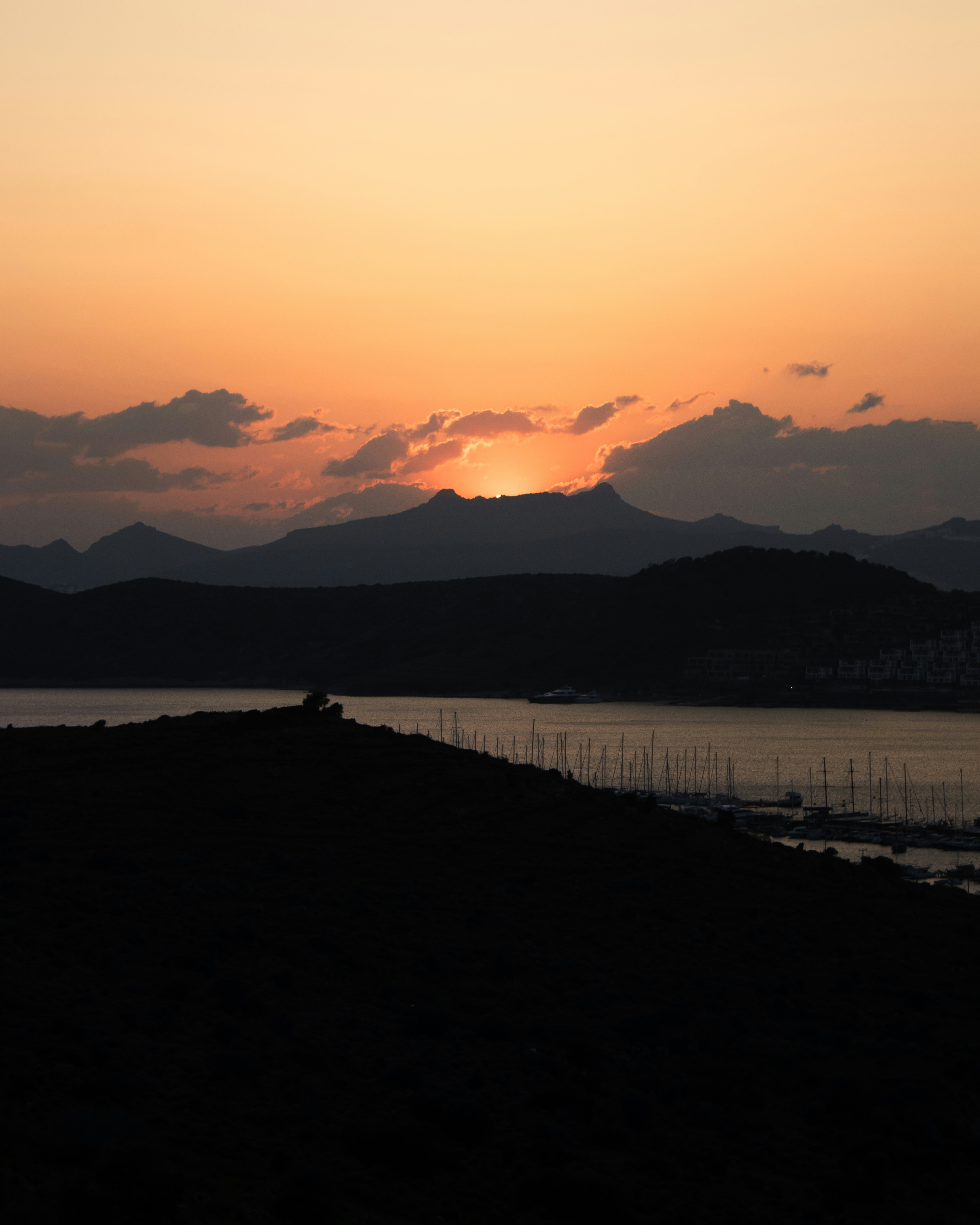 Silhouette of mountains and a bay at sunset.