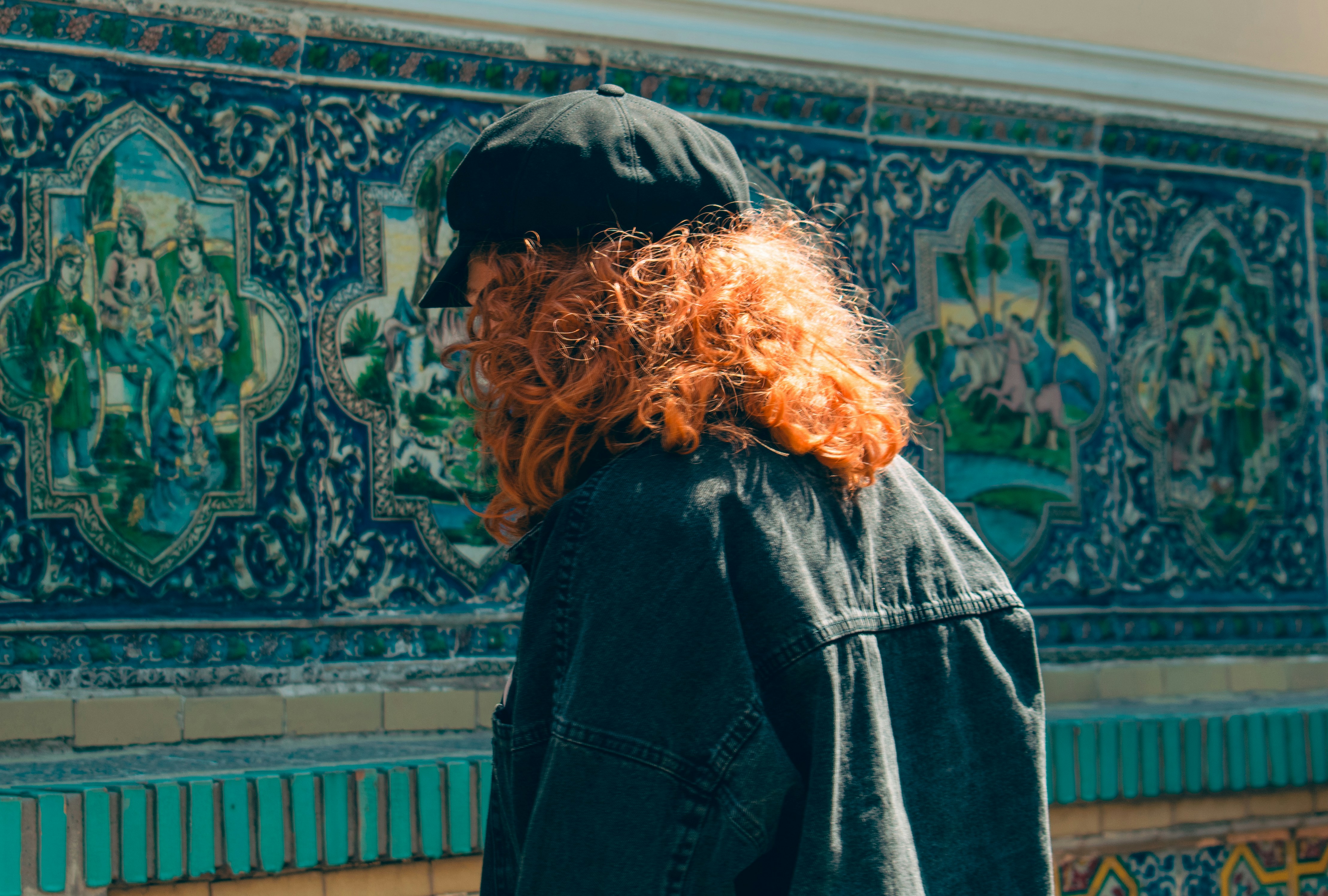 Femme aux cheveux roux bouclés et chapeau noir