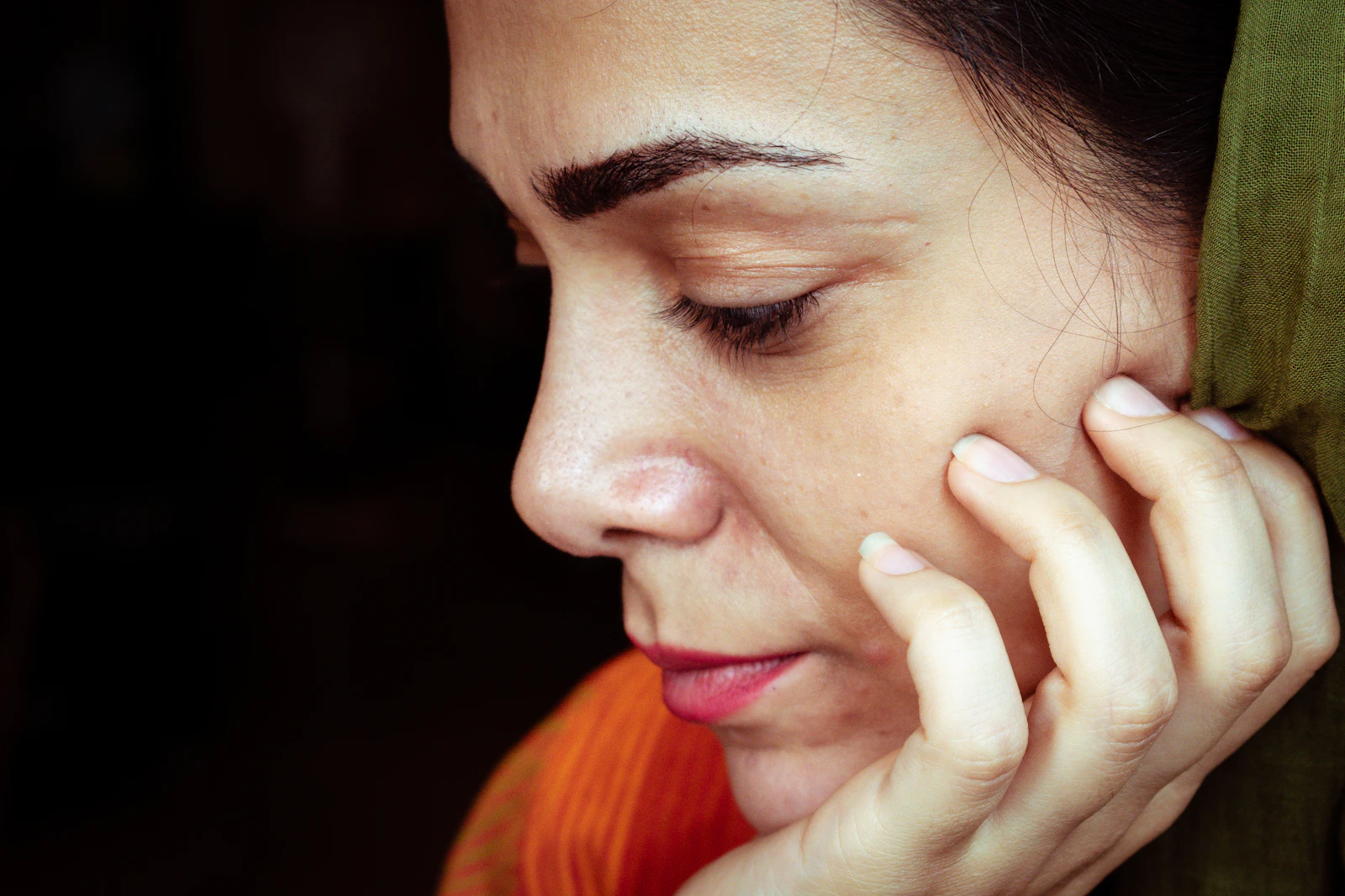 Dignified thoughtful profile portrait of a woman in soft warm light — an elegant study of mature skin