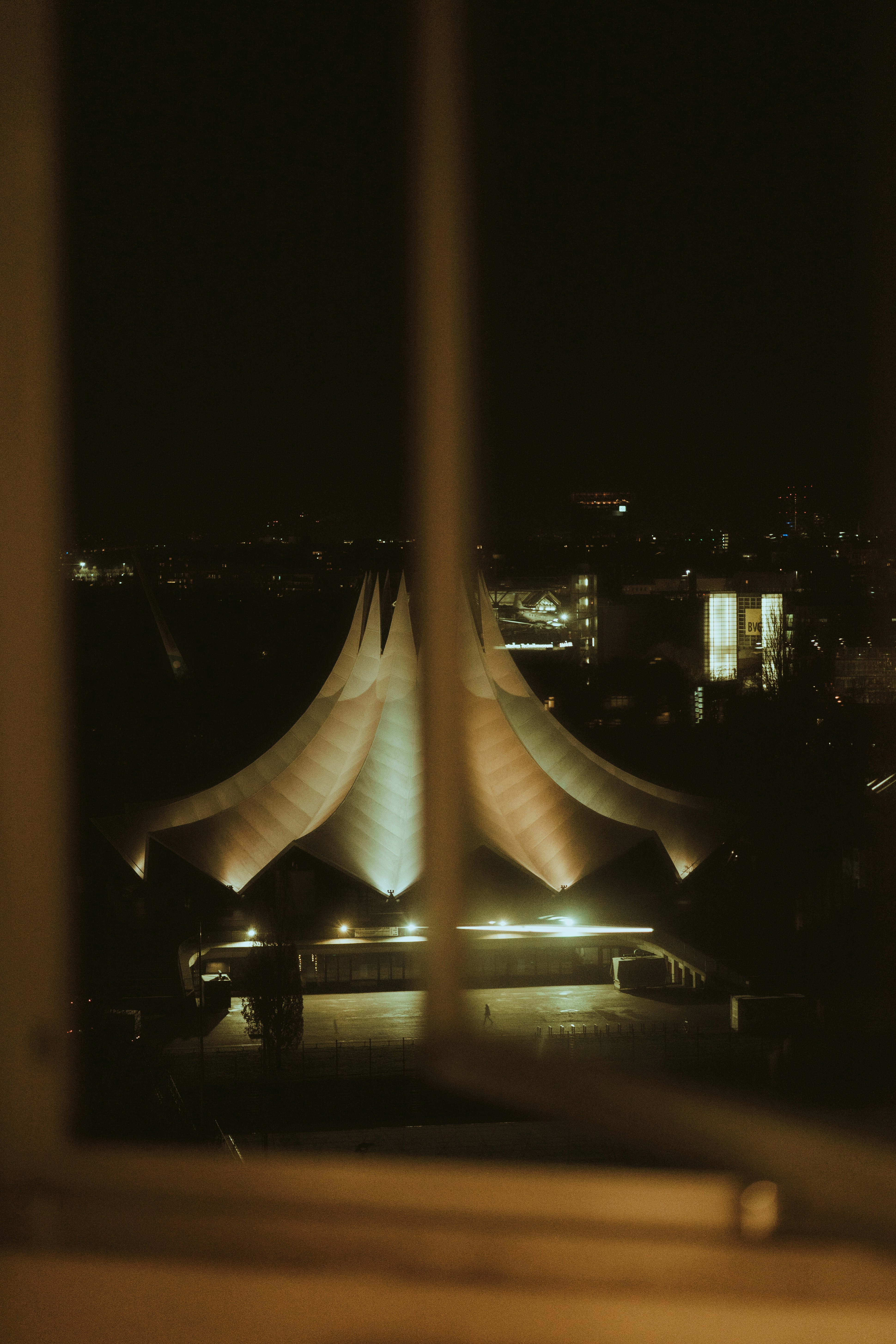 Edificio moderno illuminato di notte visto attraverso la finestra.