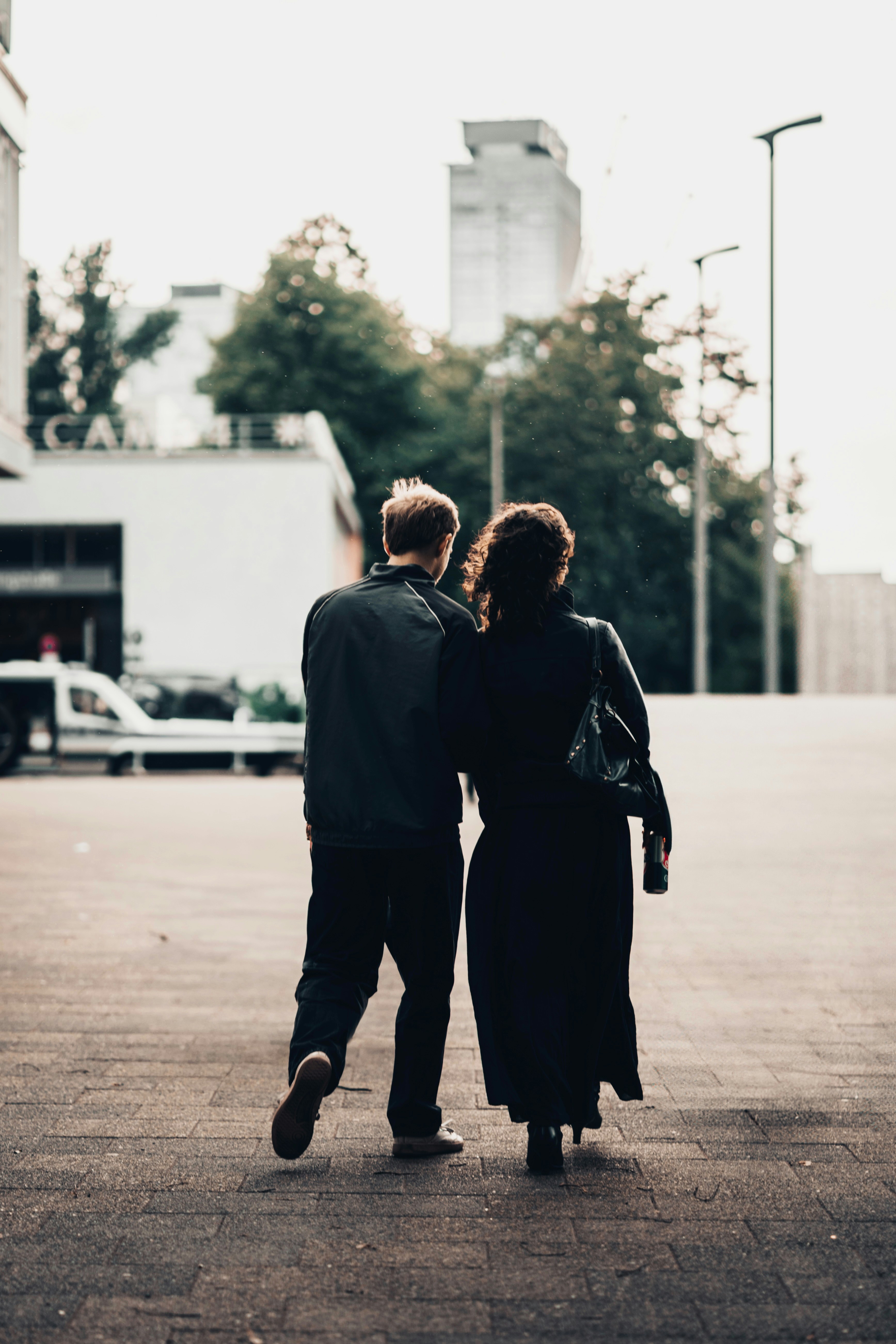 Couple walking away from camera in urban setting