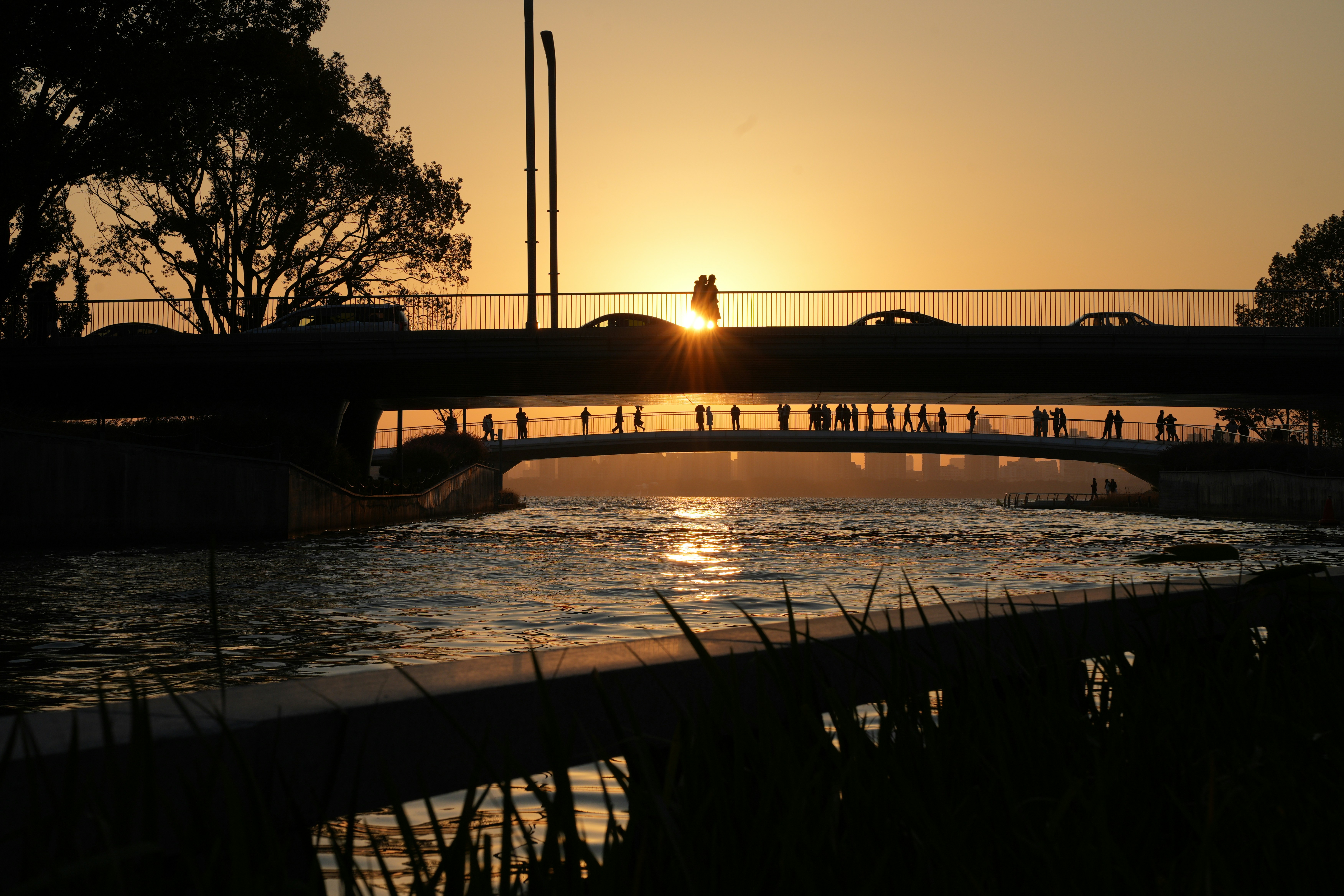 Sunset over a bridge with people walking