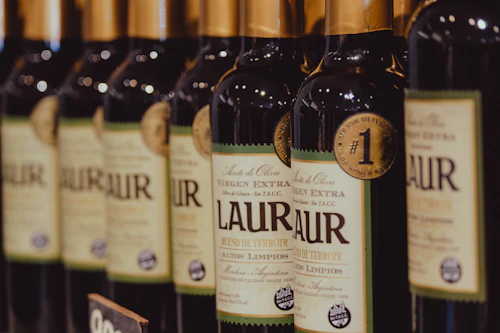 Row of dark oil bottles with gold labels