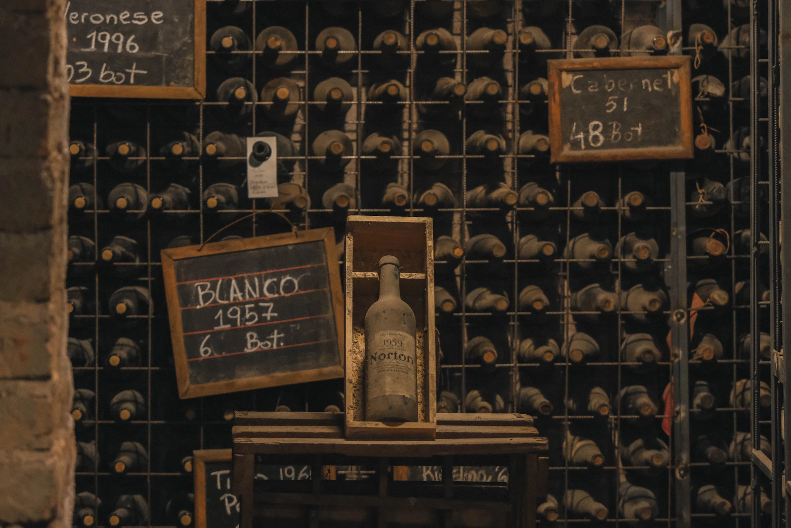 Bottles and chalkboard vintage markers in a Mendoza bodega cellar