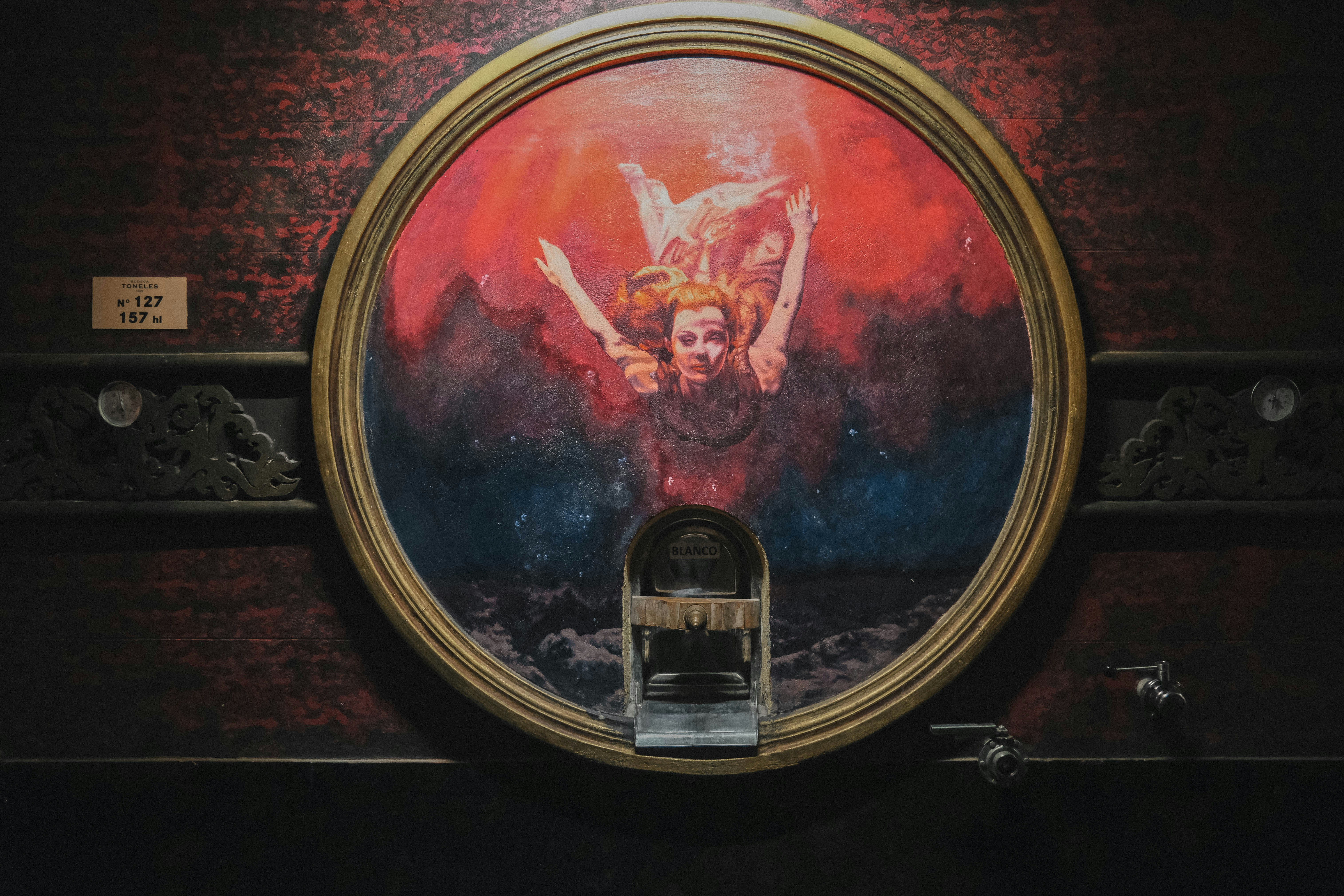 Pintura circular de una mujer cayendo entre colores abstractos