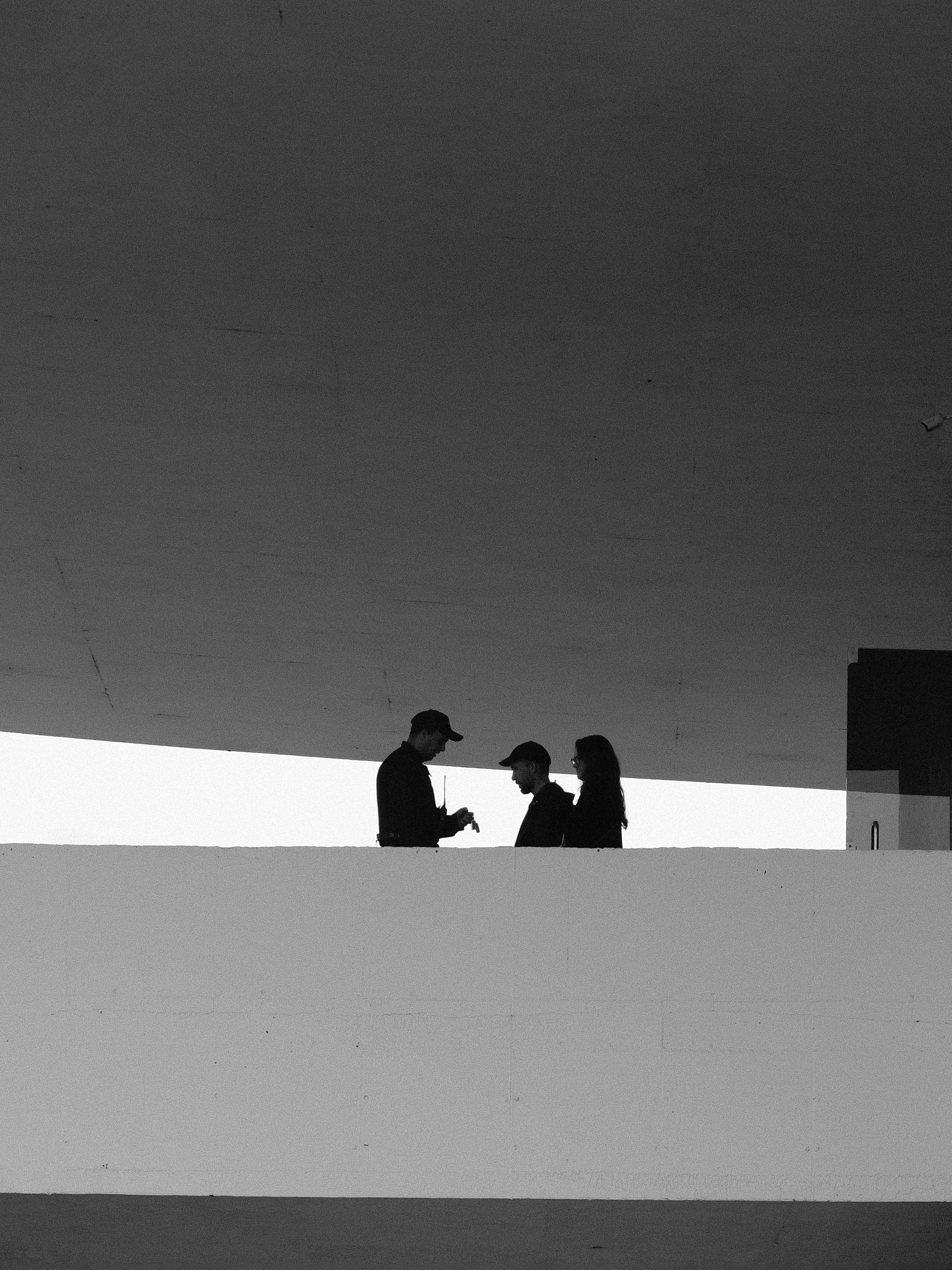 Tres personas en silueta hablando al aire libre