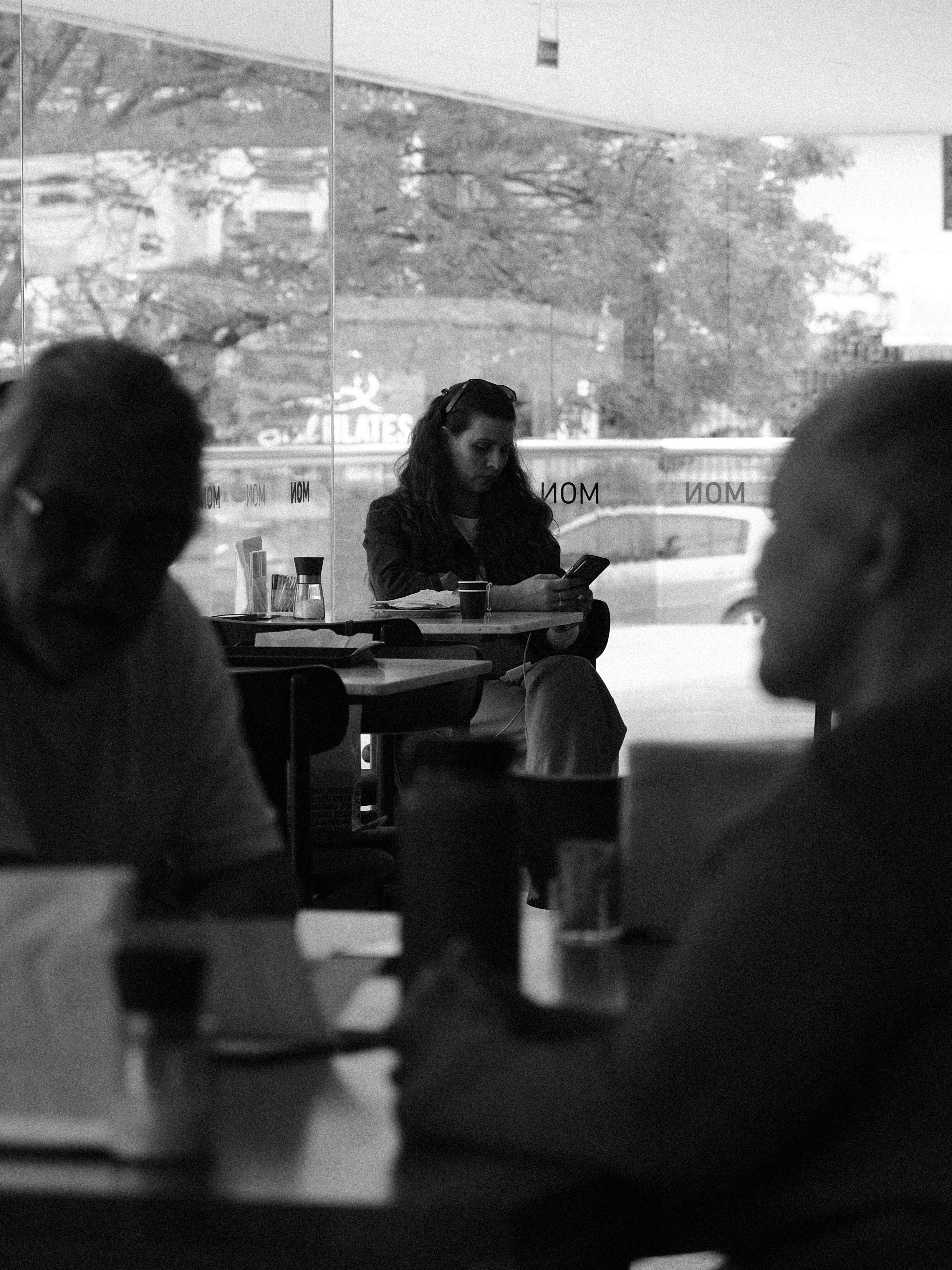 People in a cafe looking at phones and using phones.