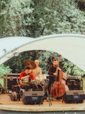 A jazz band performs outdoors under a white canopy