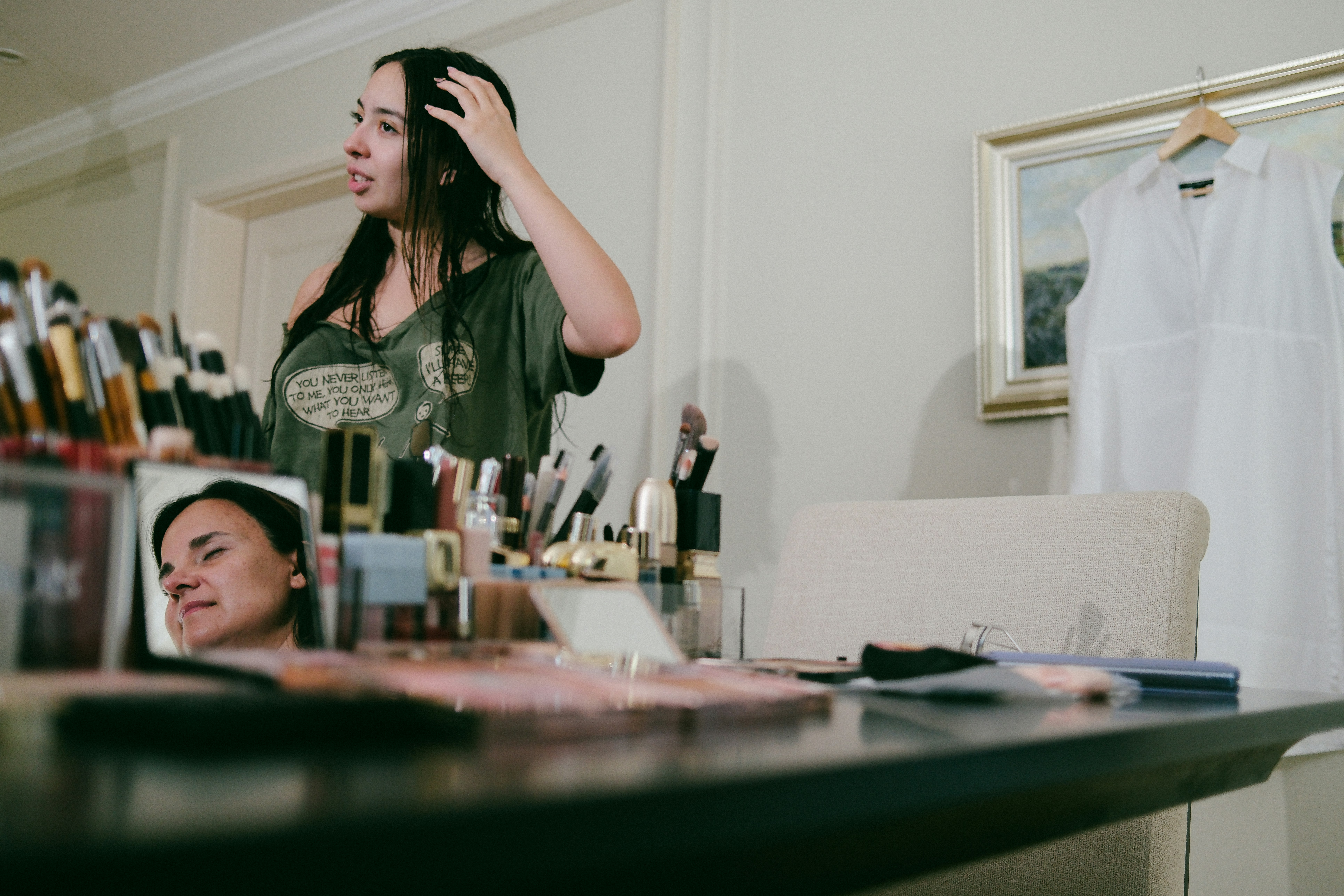 Woman applying makeup at a vanity table