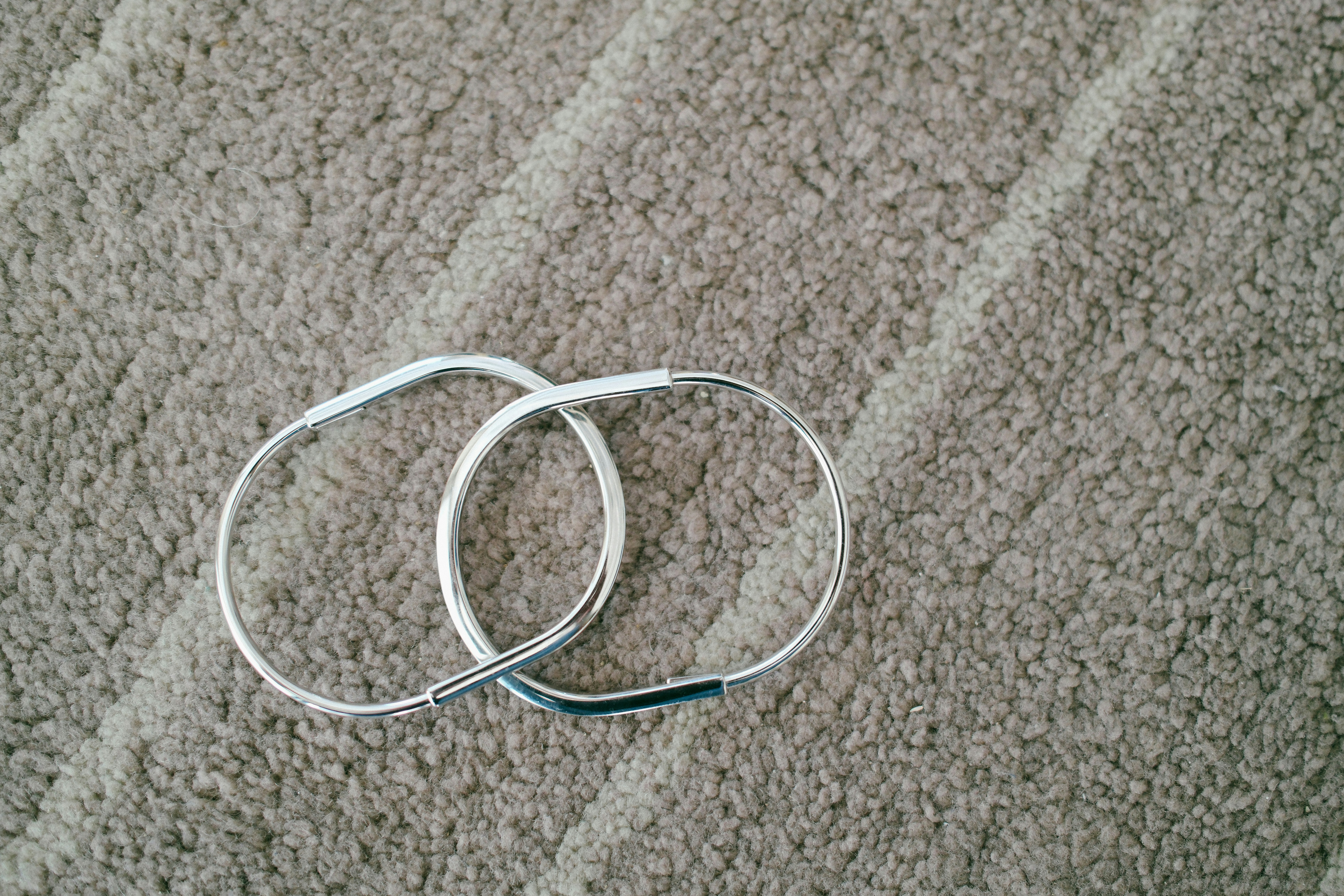 Two silver bracelets on a textured surface