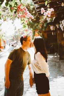 Couple kissing under blooming pink flowers
