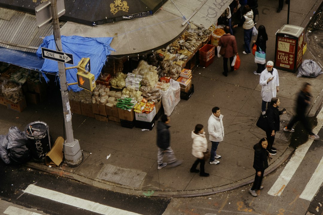People crossing street near outdoor market stalls