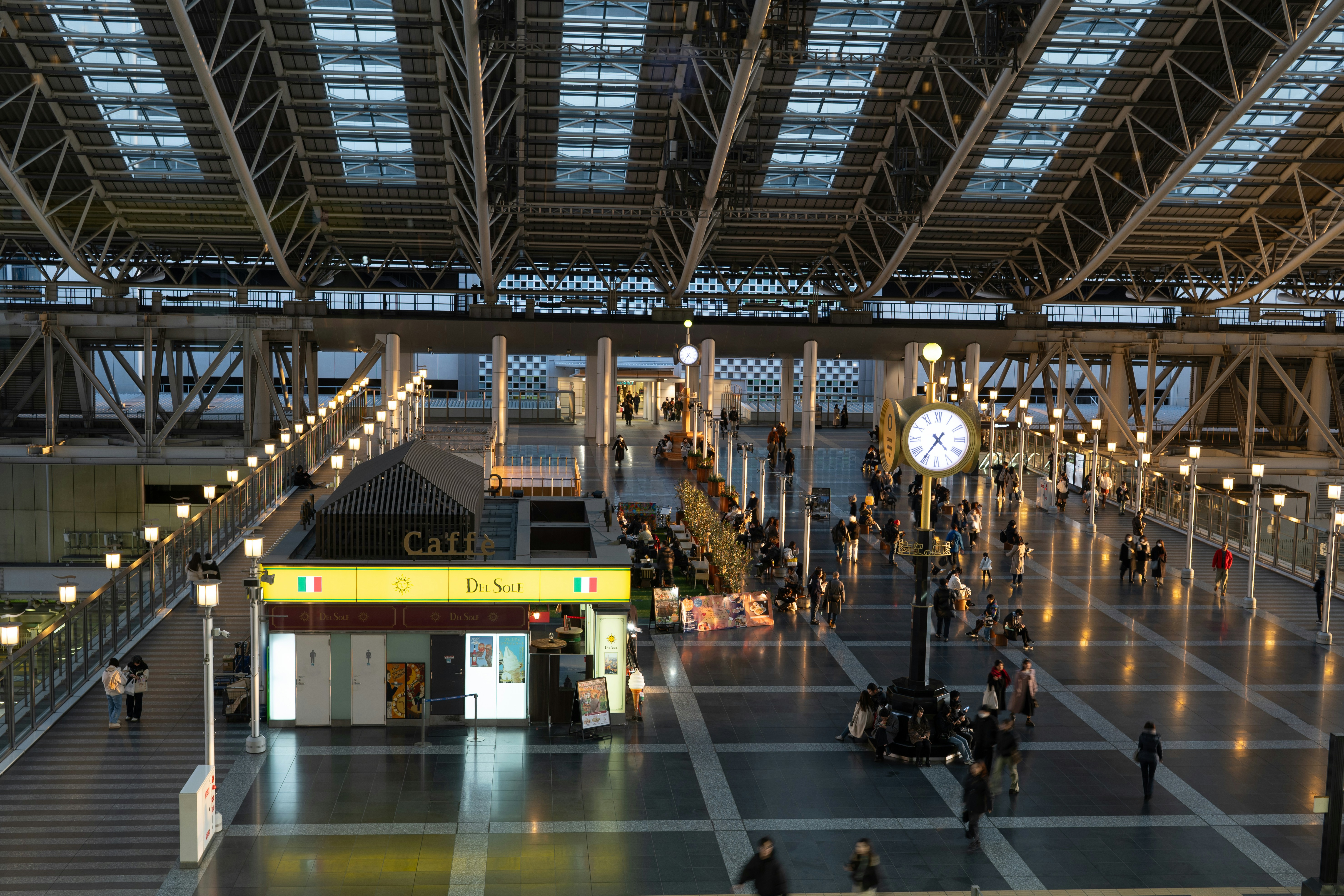 Traveler checking phone for hotel bookings inside a Japanese train station, late evening, winter