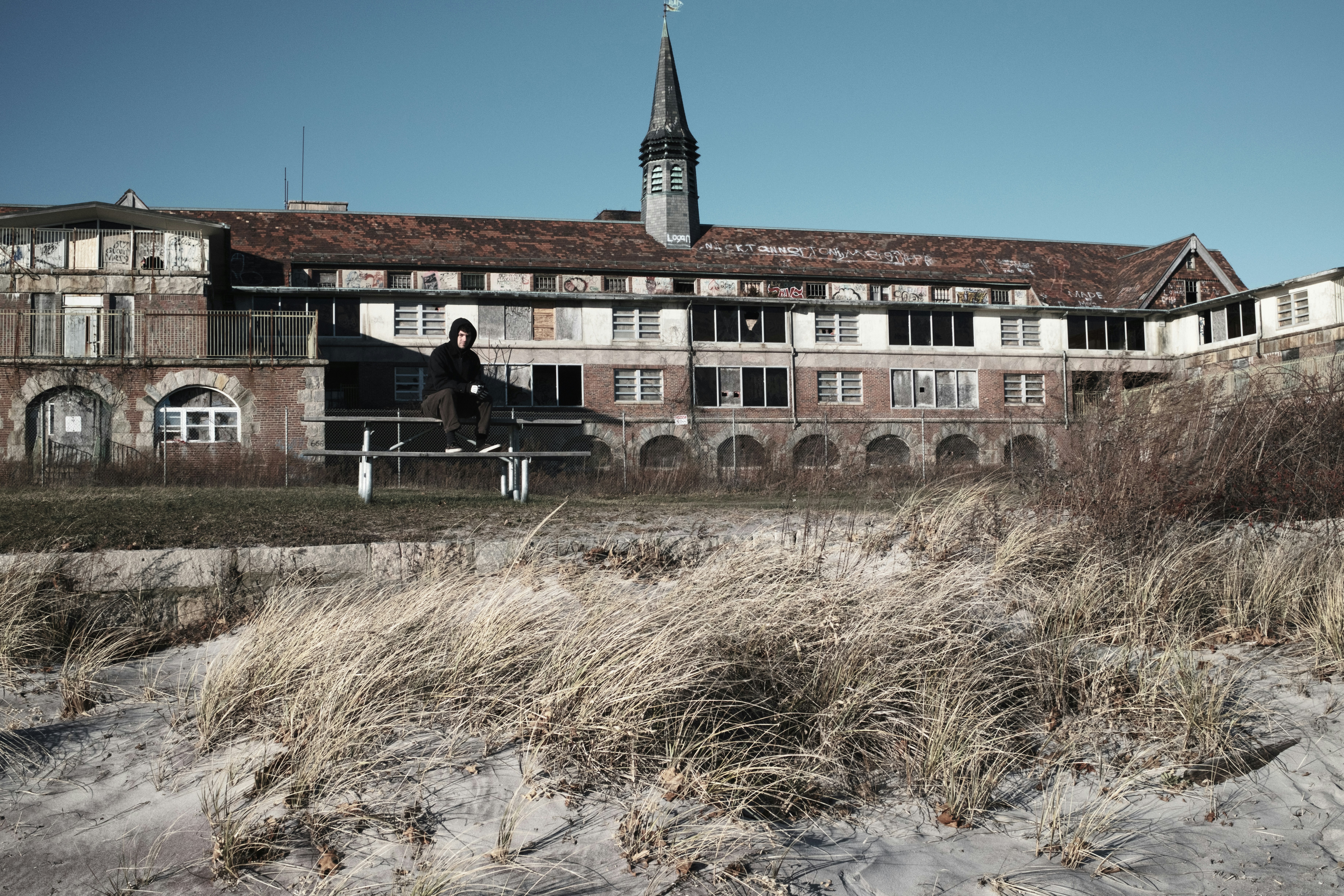Person standing outside an old, abandoned building.