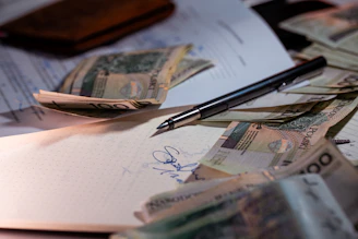 Pen and money scattered on documents