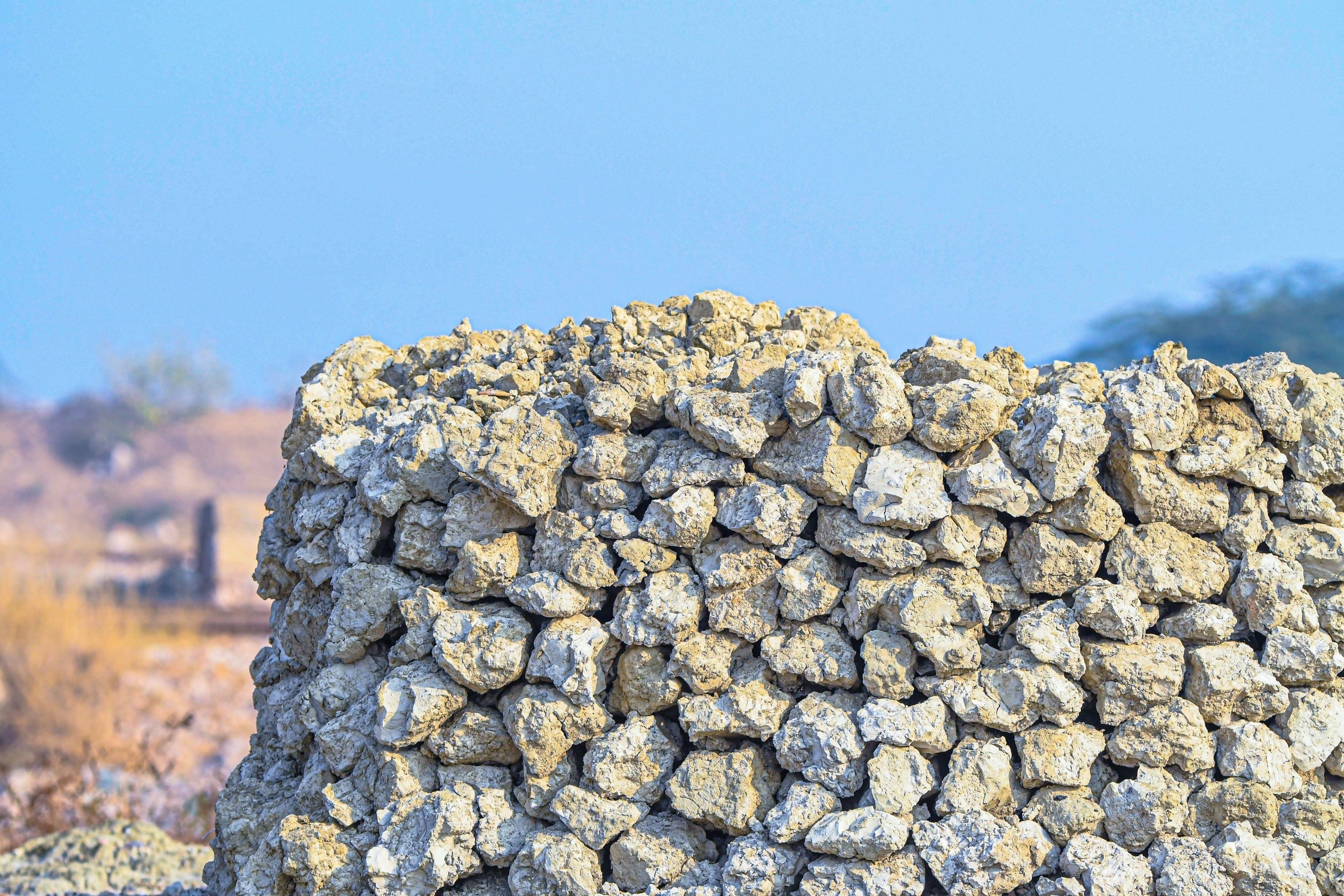 Rough stone wall against a clear blue sky