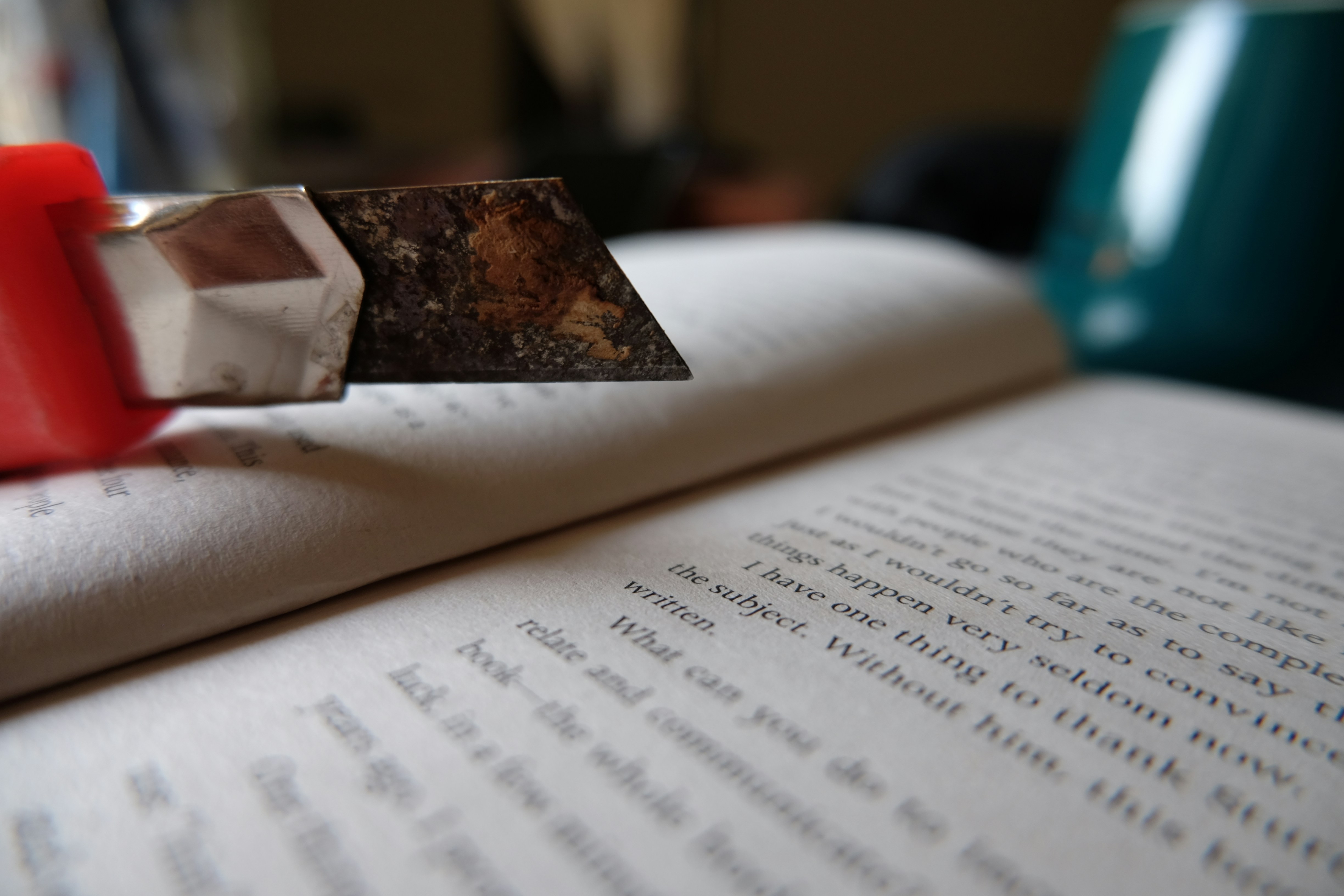 Close-up of a utility knife over an open book.
