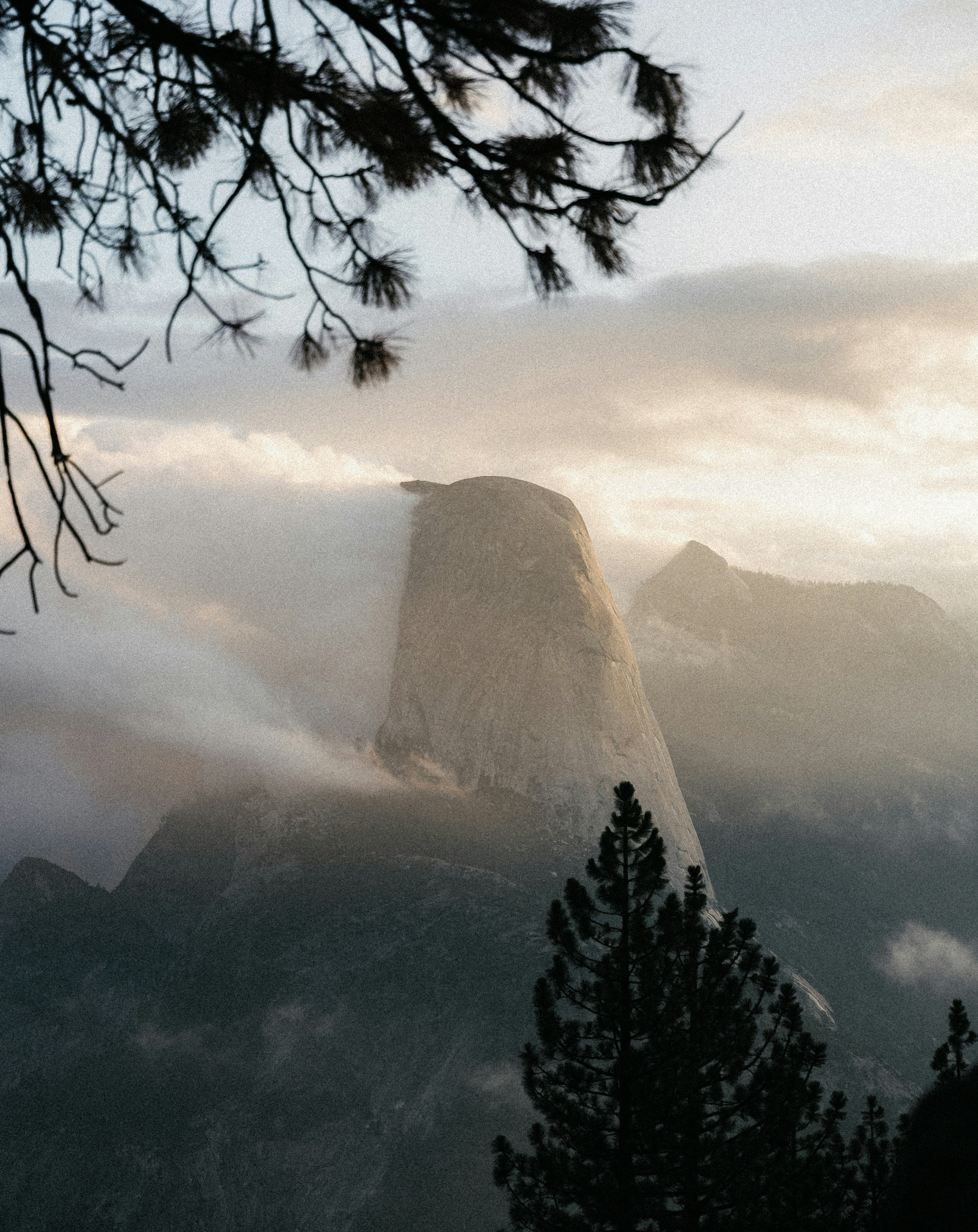 Misty mountain peak emerges from clouds at sunrise
