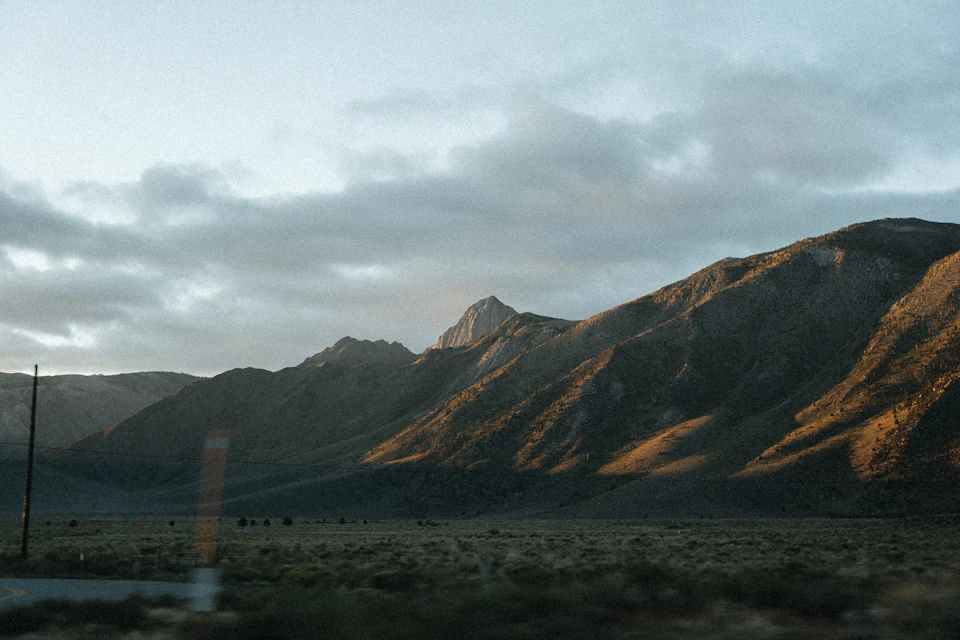 Serene mountain landscape with majestic peak standing tall against overcast gray-brown sky backdrop