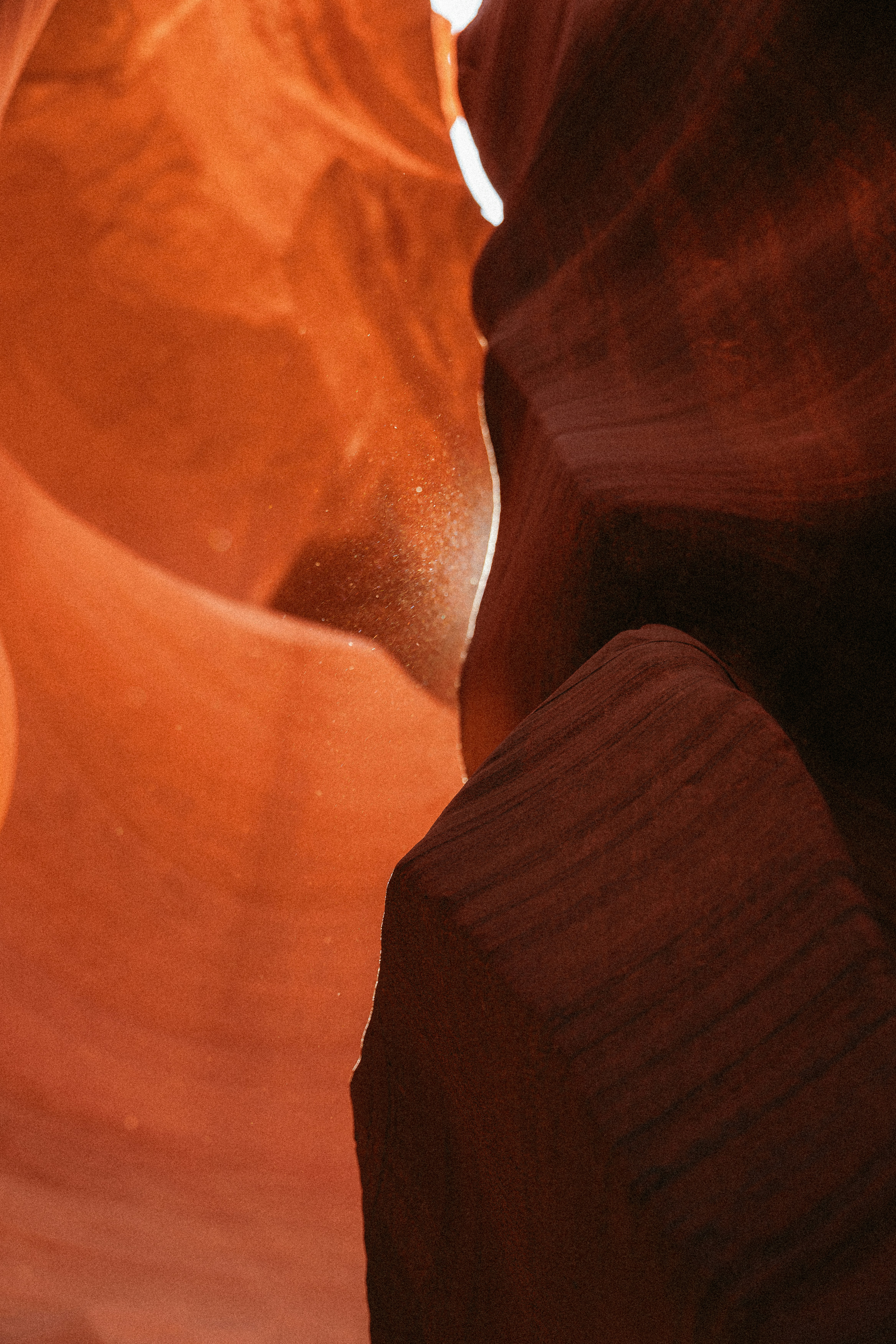 Sunlight streams through a narrow sandstone canyon.