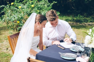 Bride and groom signing wedding documents outdoors