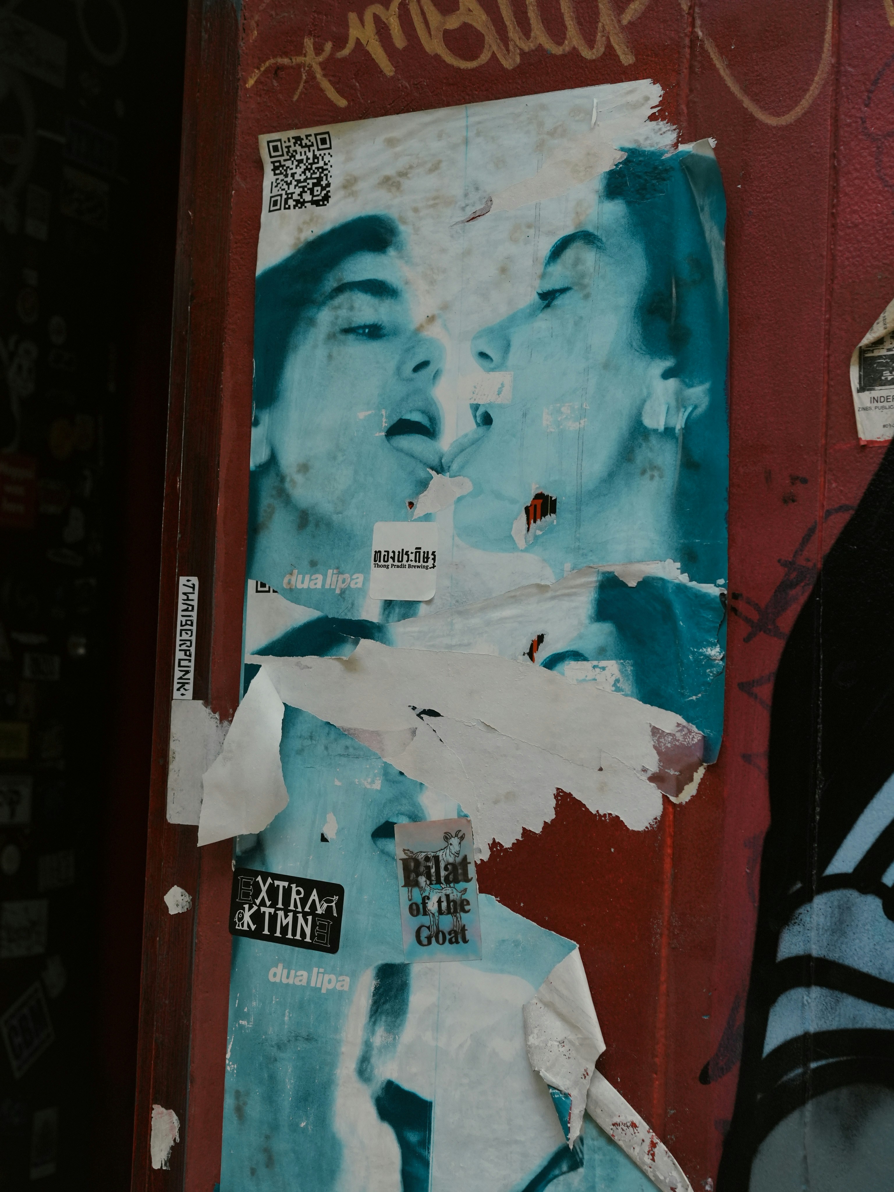 Zwei Gesichter, die sich auf verwitterten Plakaten küssen.