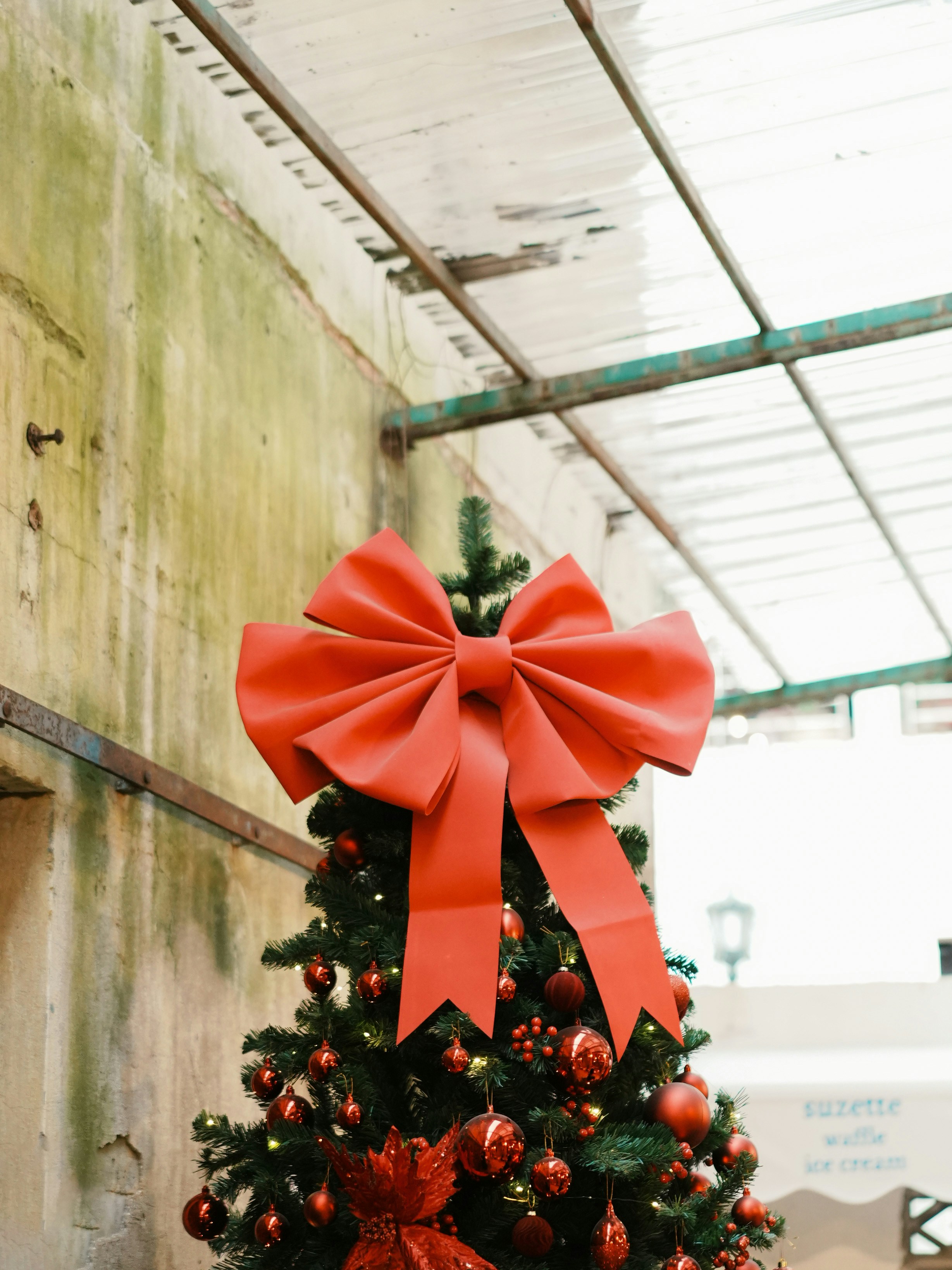 Weihnachtsbaum geschmückt mit einer großen roten Schleife und Ornamenten