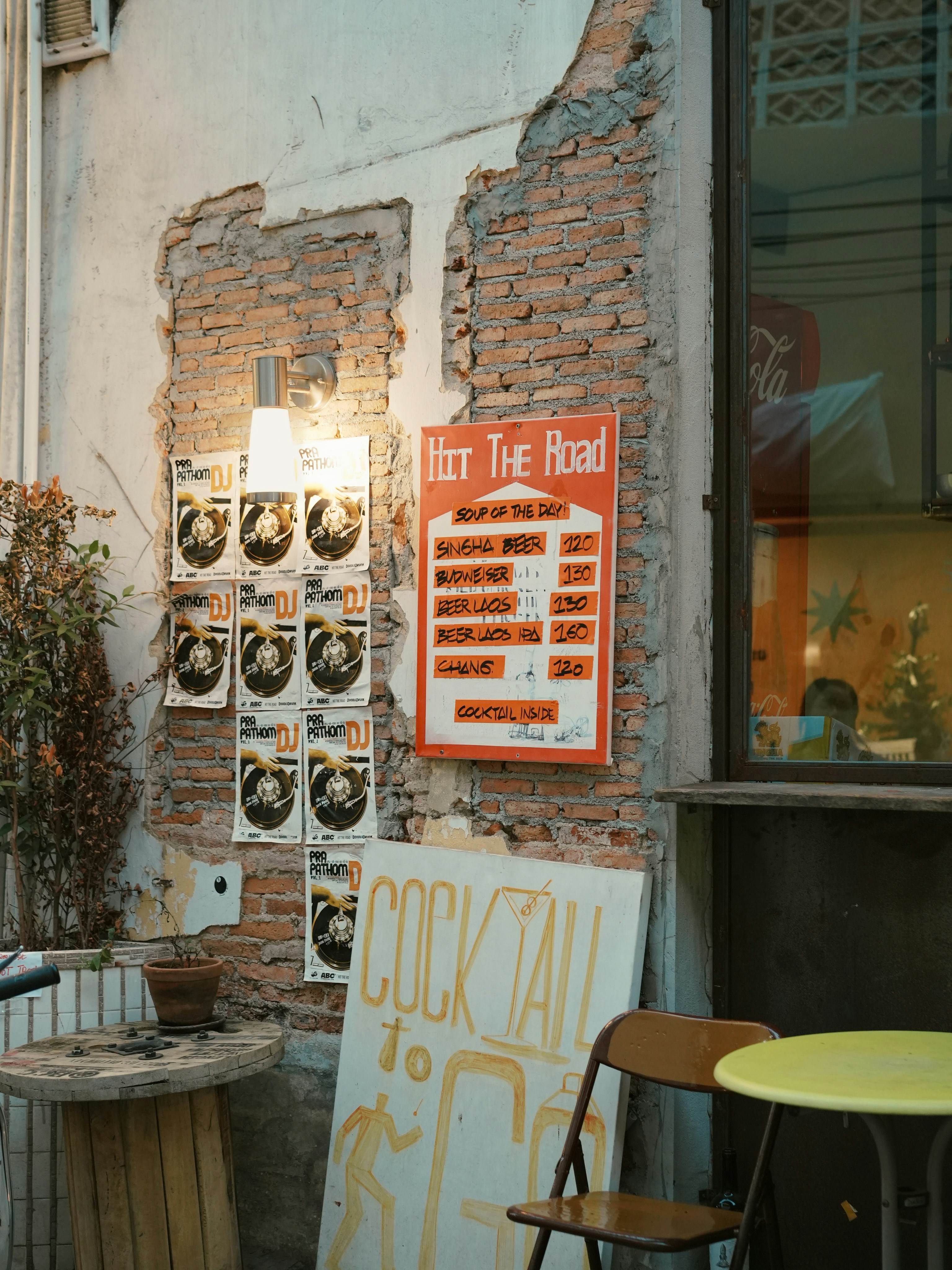 Backsteinwand mit Plakaten und einem Cocktailschild