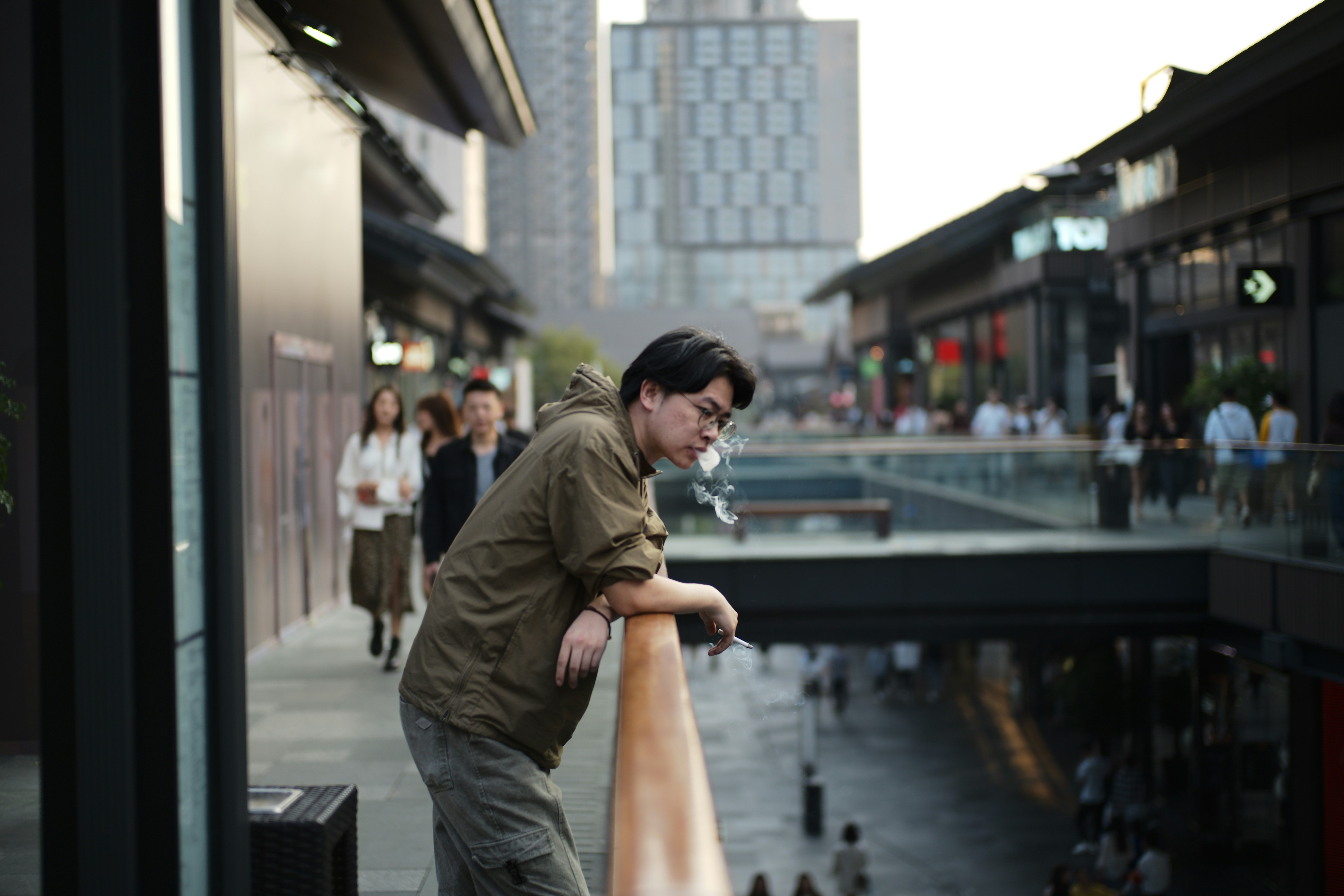 Man leaning on railing overlooking busy street