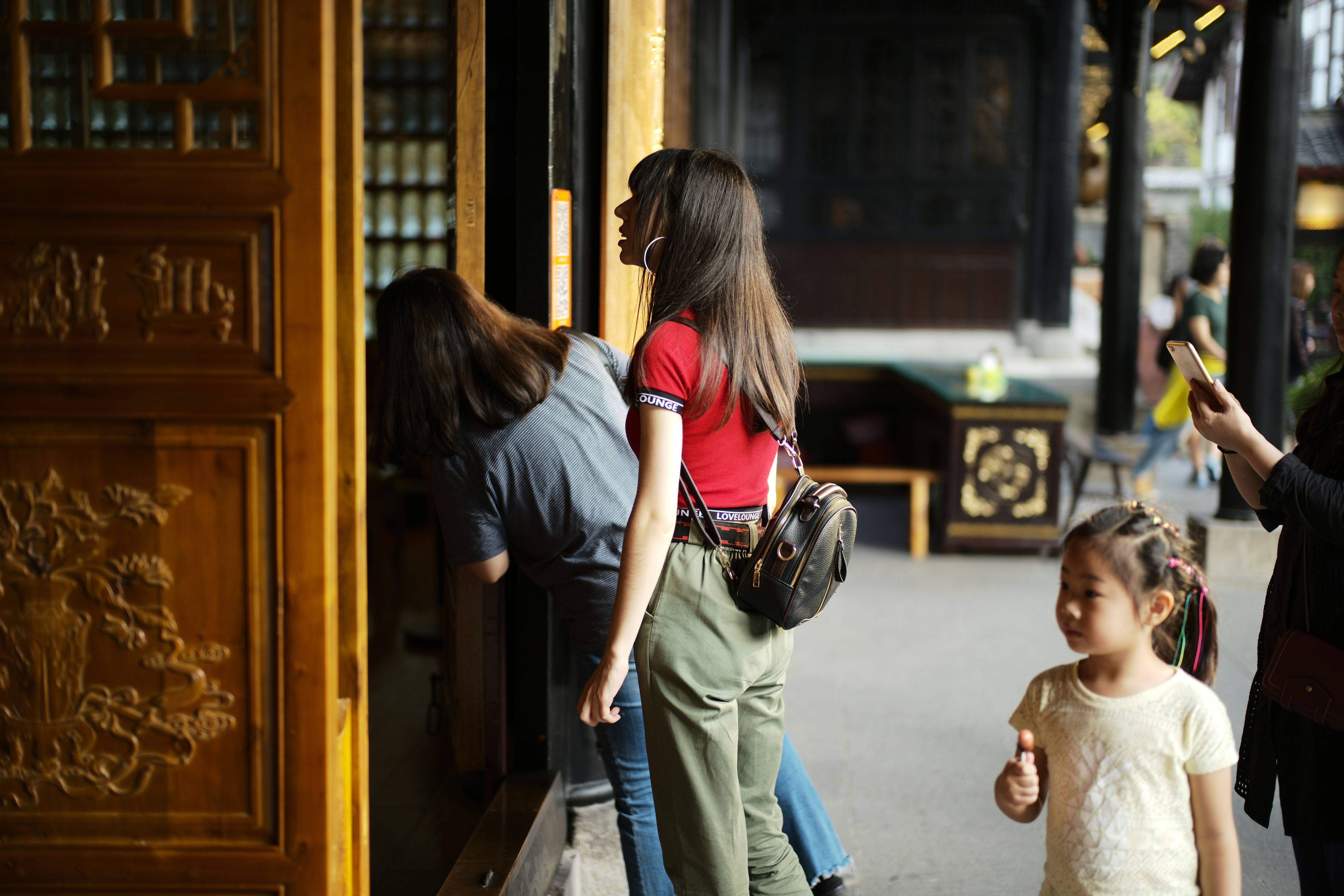 People looking into a building with ornate carvings.